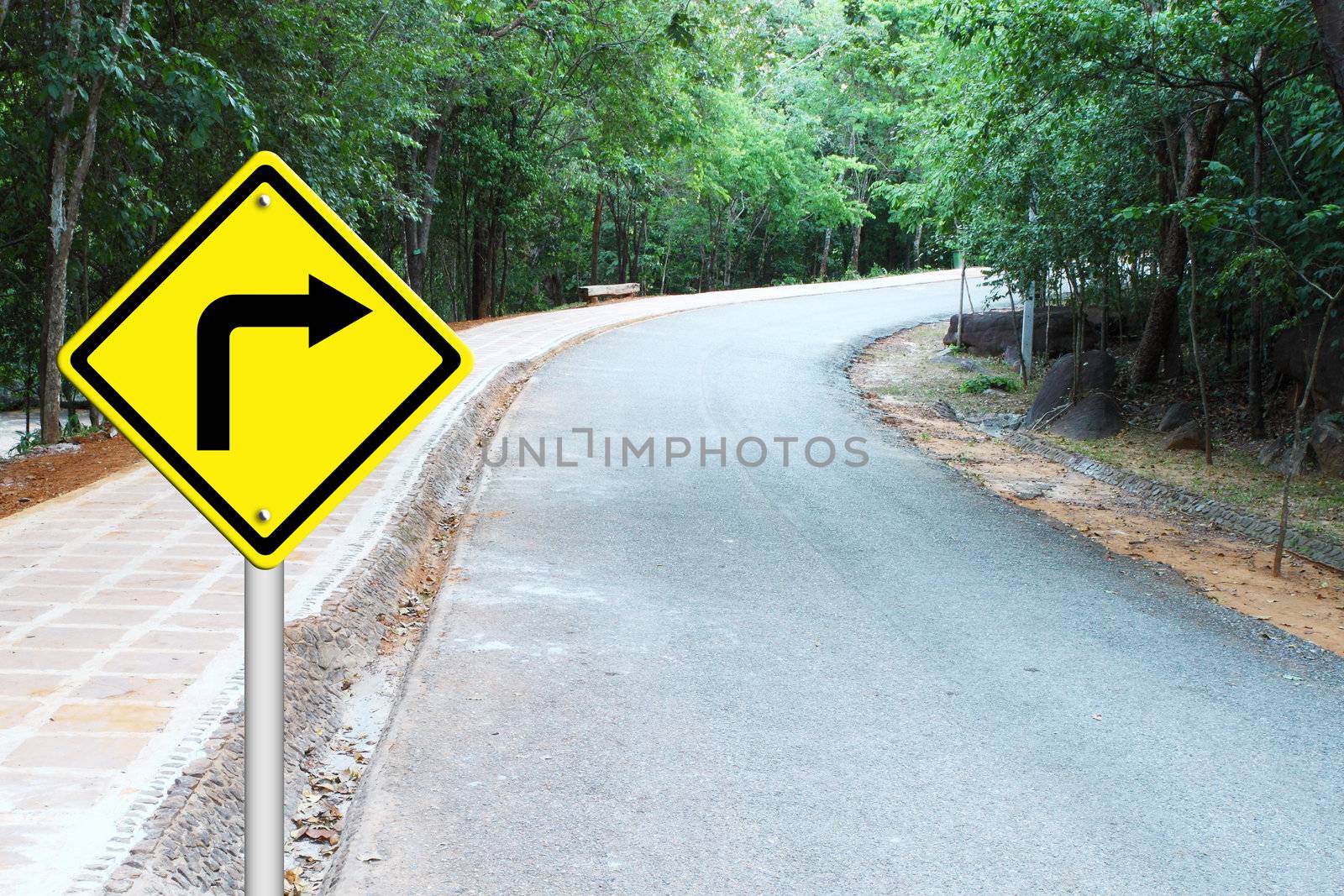 Turn right warning sign on a curve road