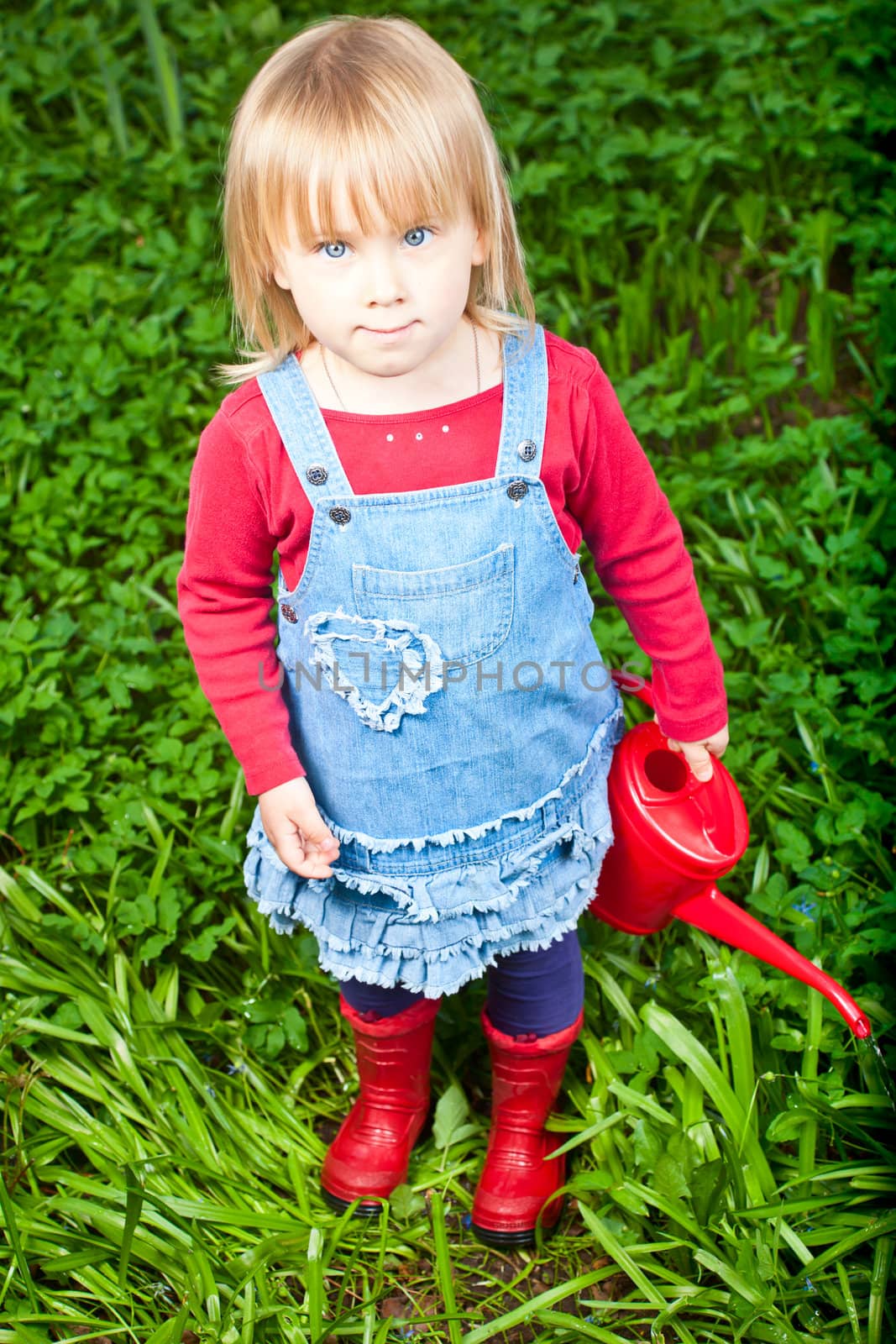 Little girl holding red watering can