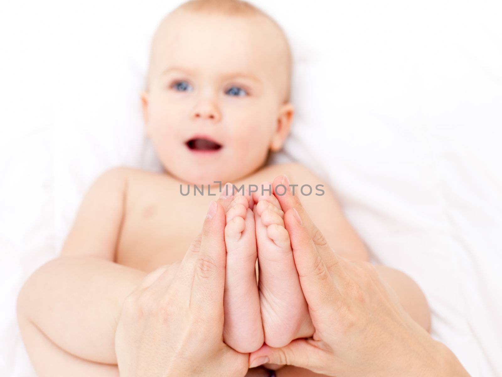 Masseur massaging little baby's feet, shallow focus