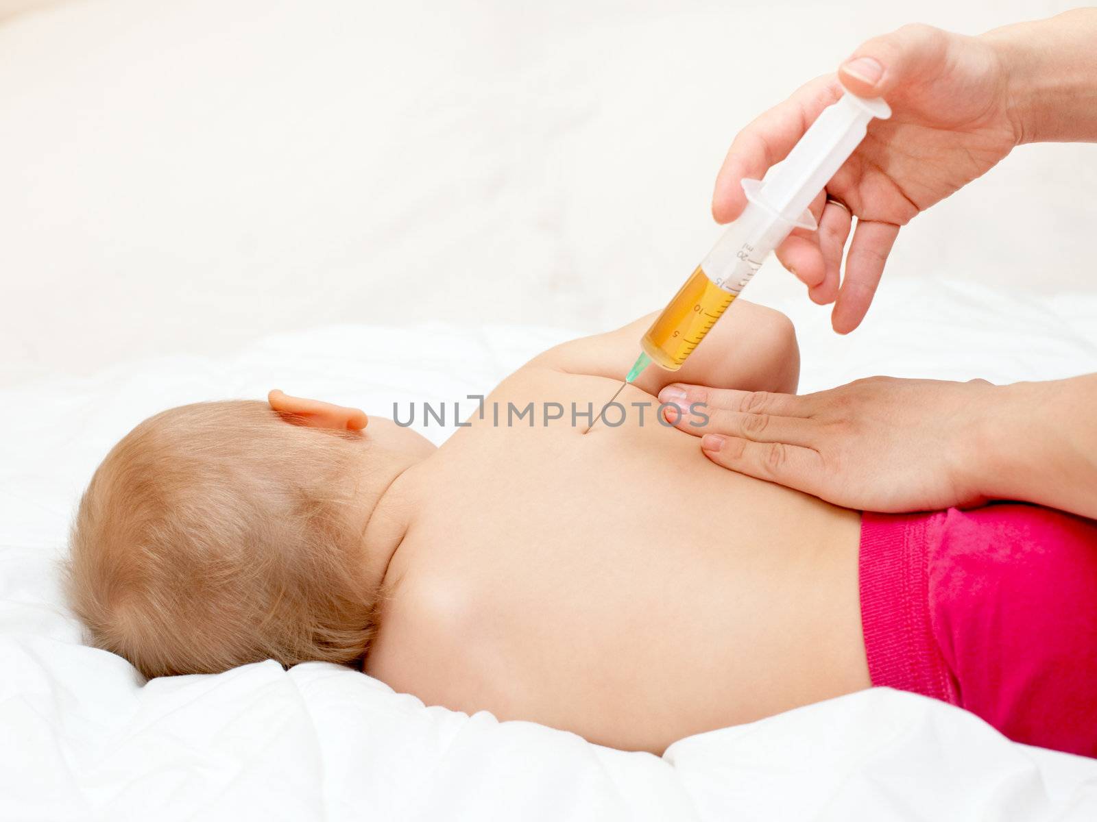 Doctor giving a child an injection in shoulder-blade, shallow DOF