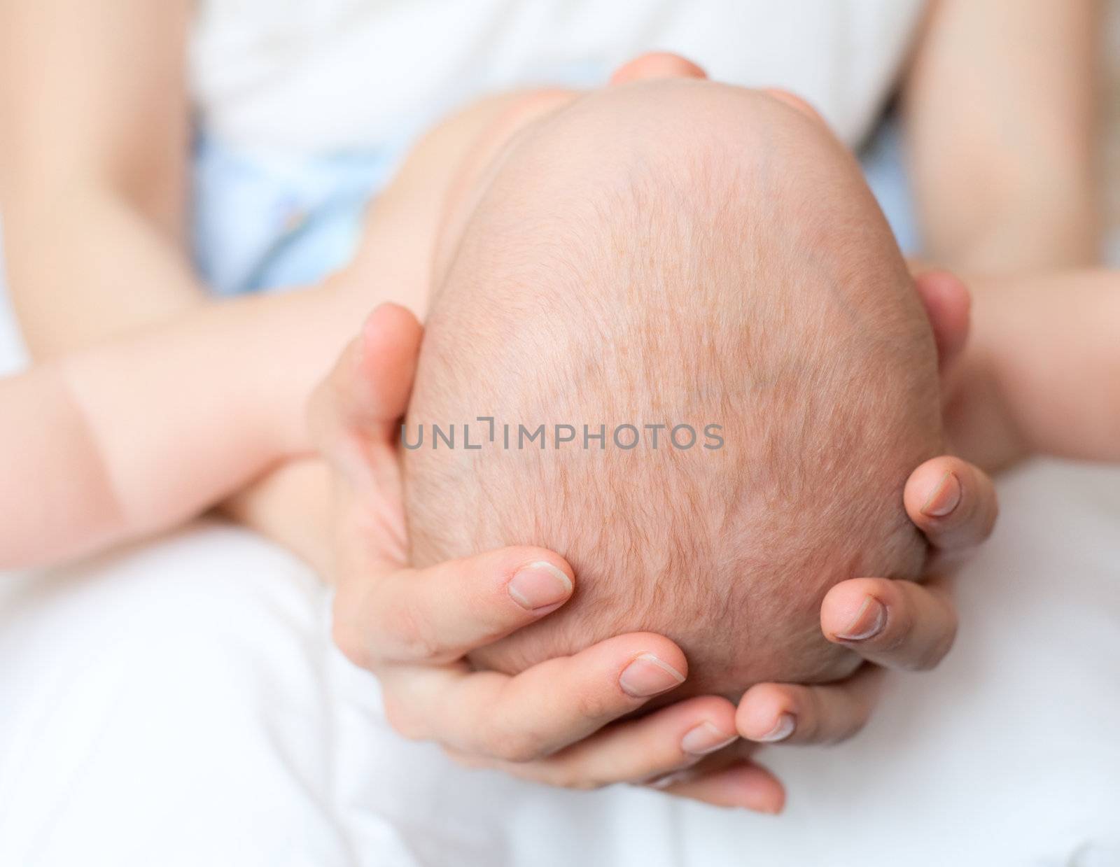 Mother holding her child's head, shallow DOF