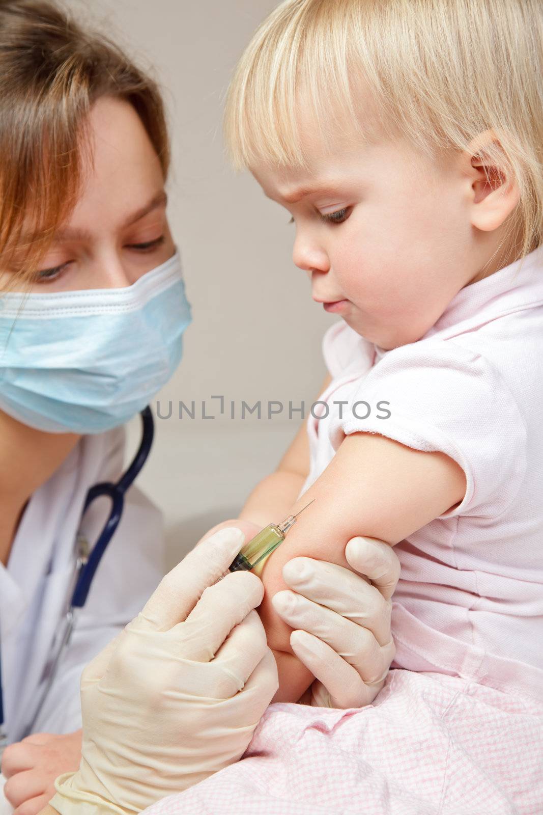 Doctor giving a child an intramuscular injection in arm