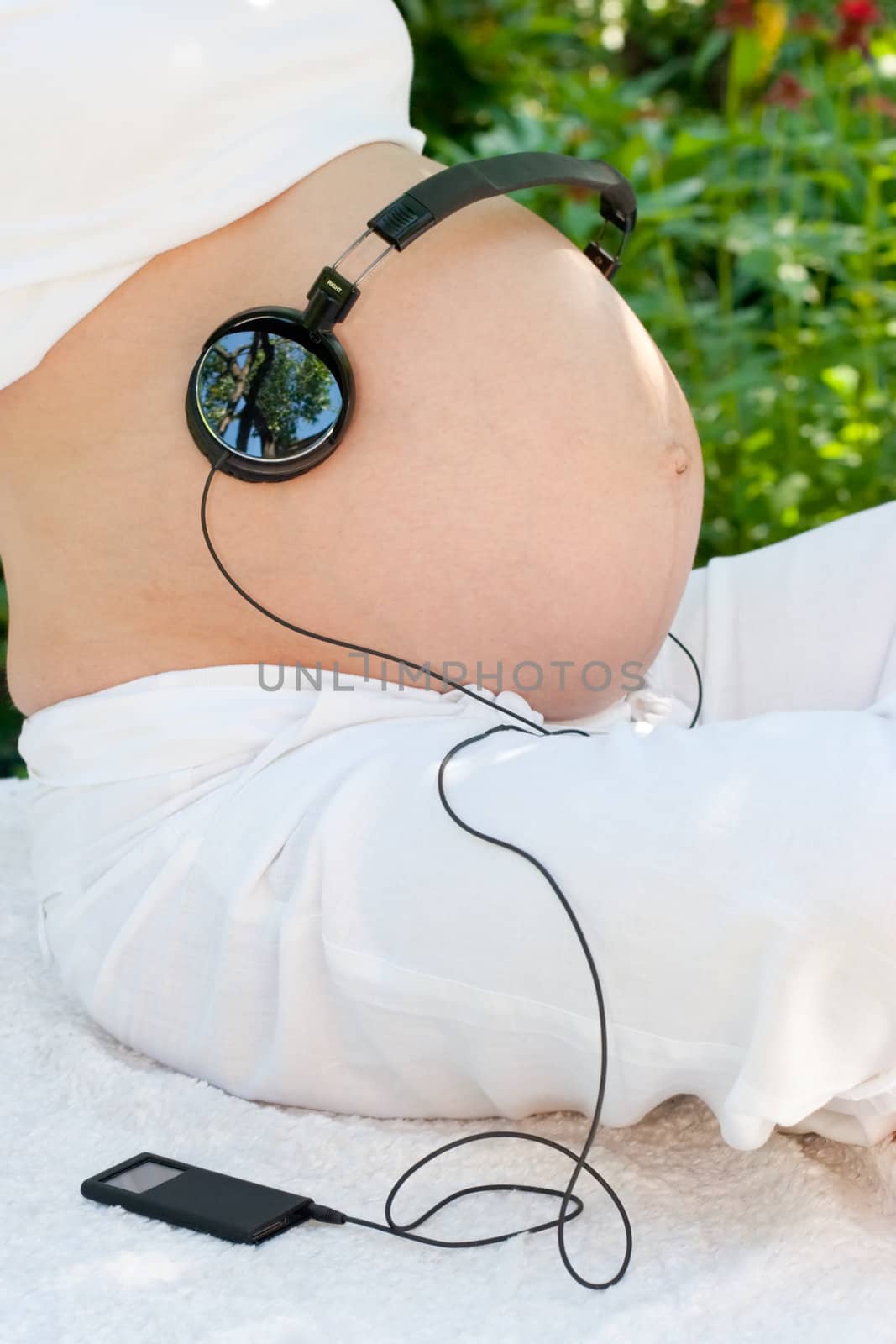 Headphones on a pregnant woman's belly