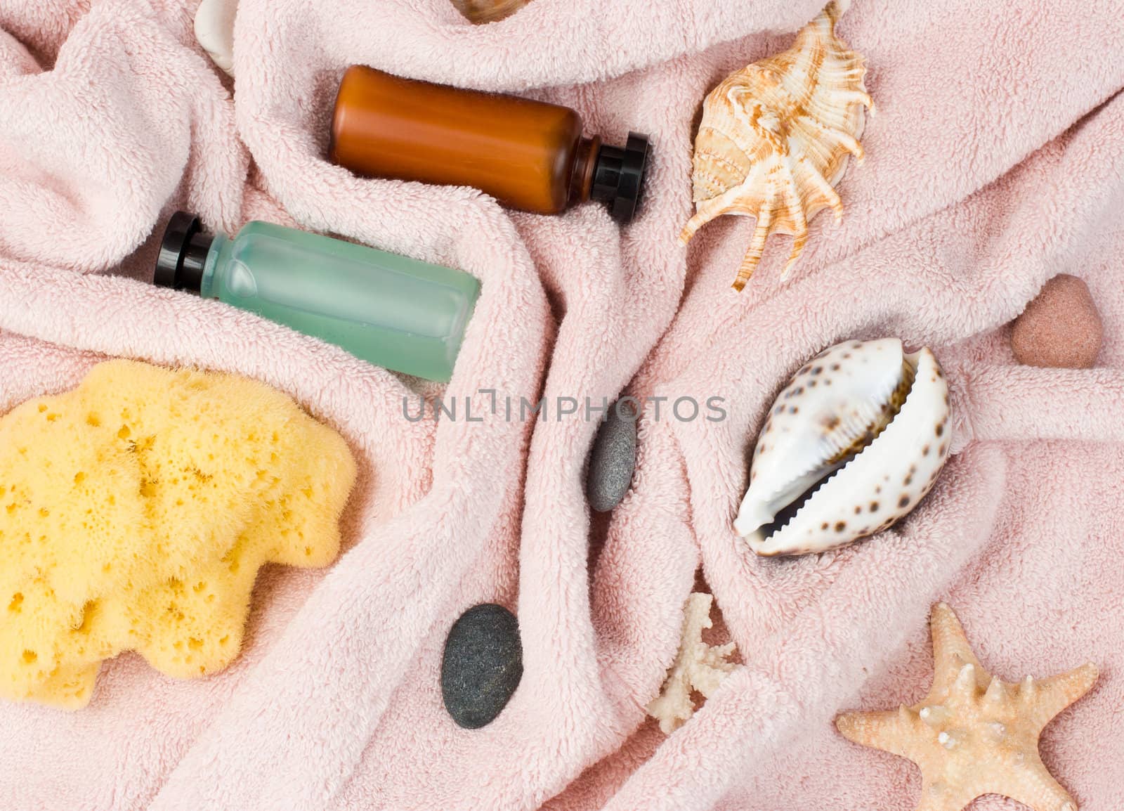 Collection of various spa or bath accessories on pink towel