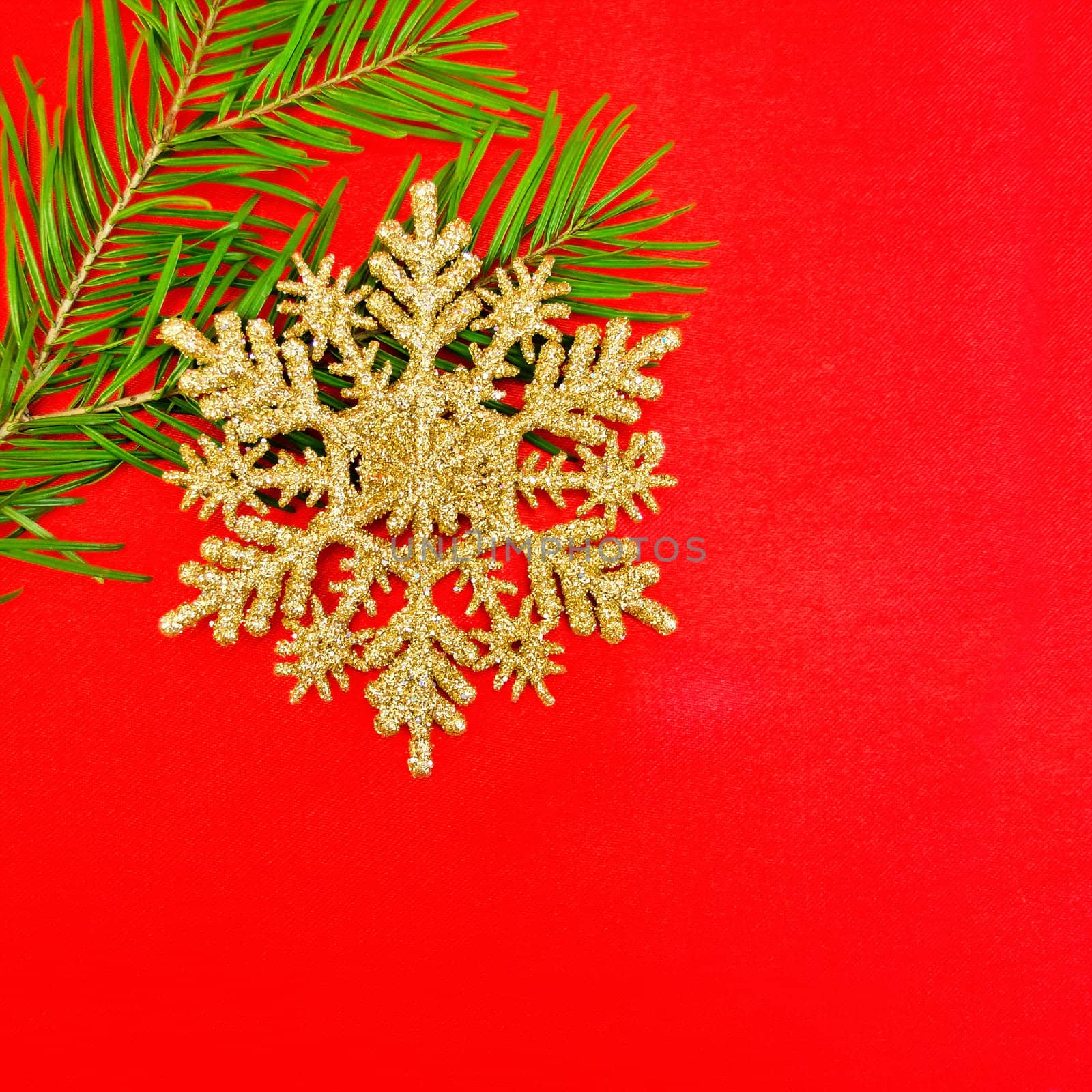 Christmas golden snowflake, spruce branches on a background of red silk