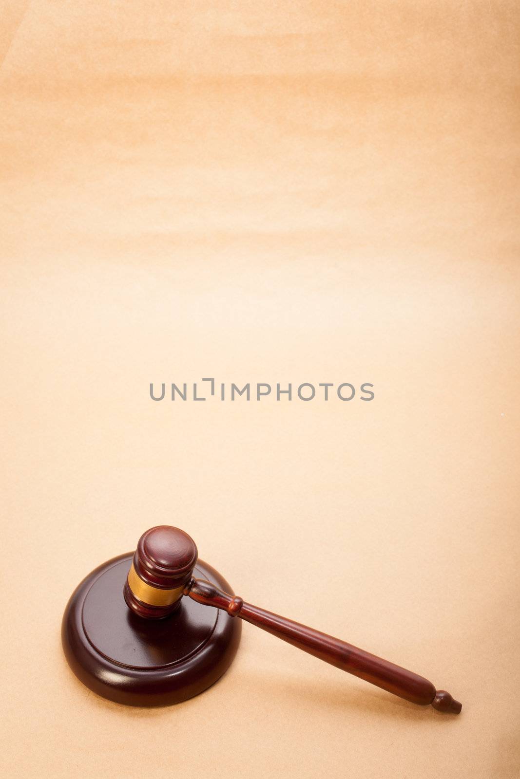 A wooden gavel and soundboard on a light brown background.