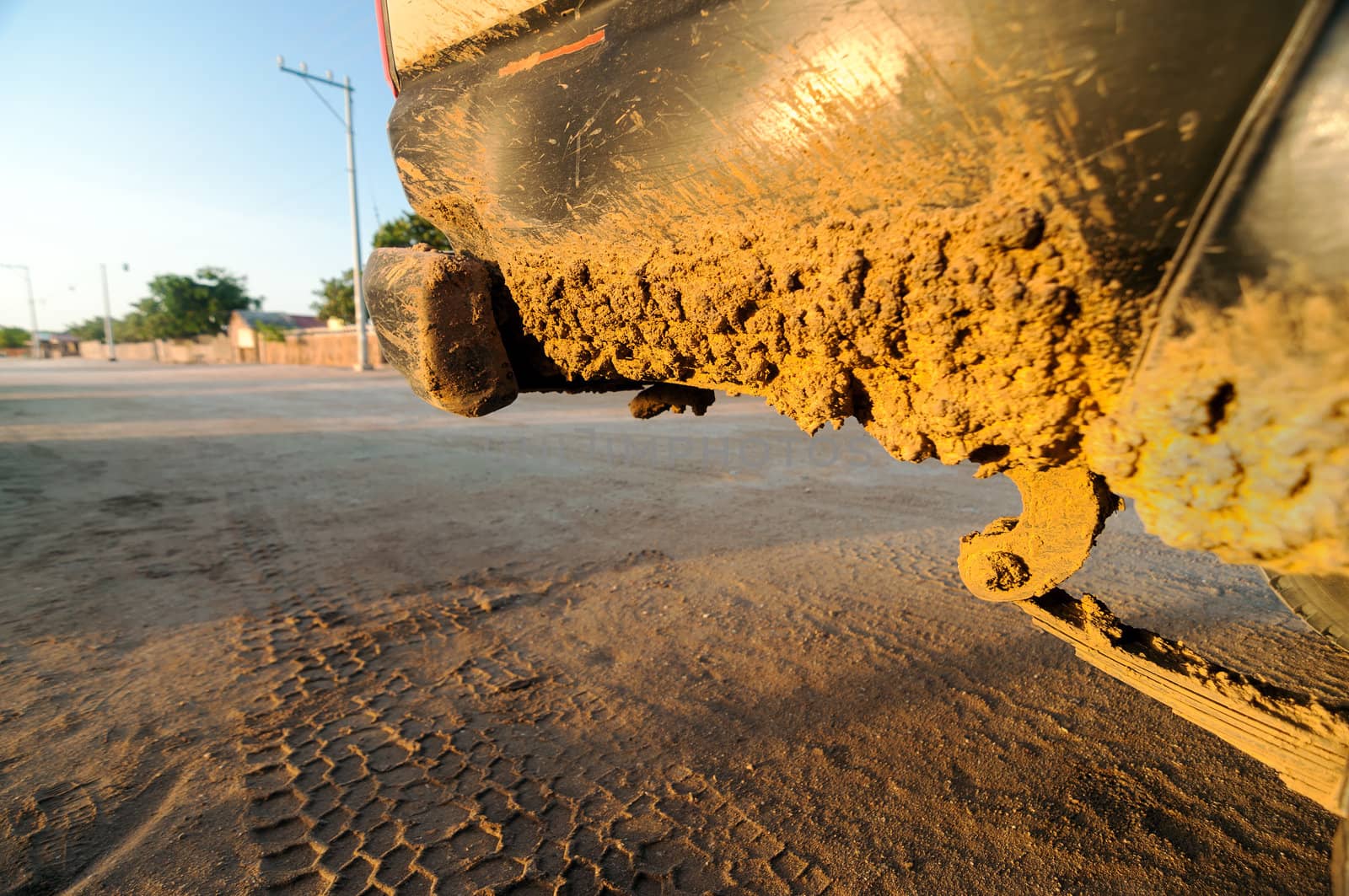 A muddy dirty SUV with a beach town in the background