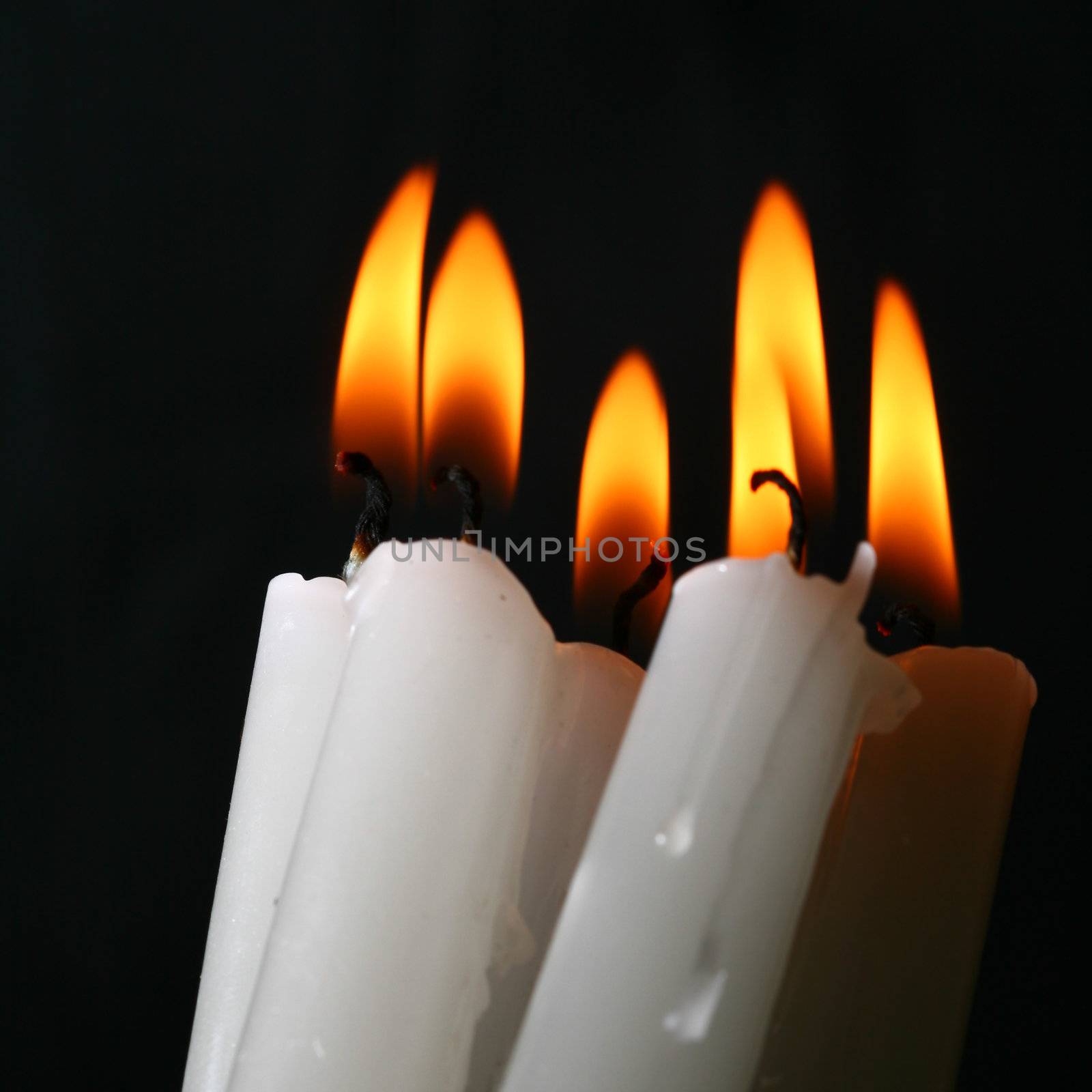 sacred candles in dark on black background