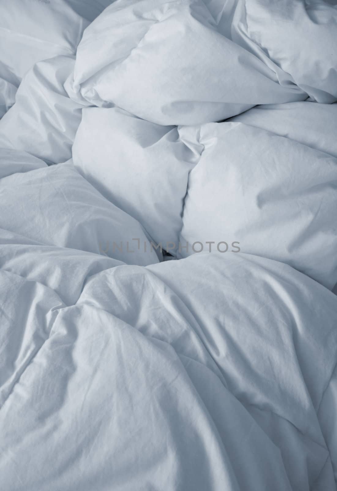 Bedclothes broken with white sheets in the morning. upright