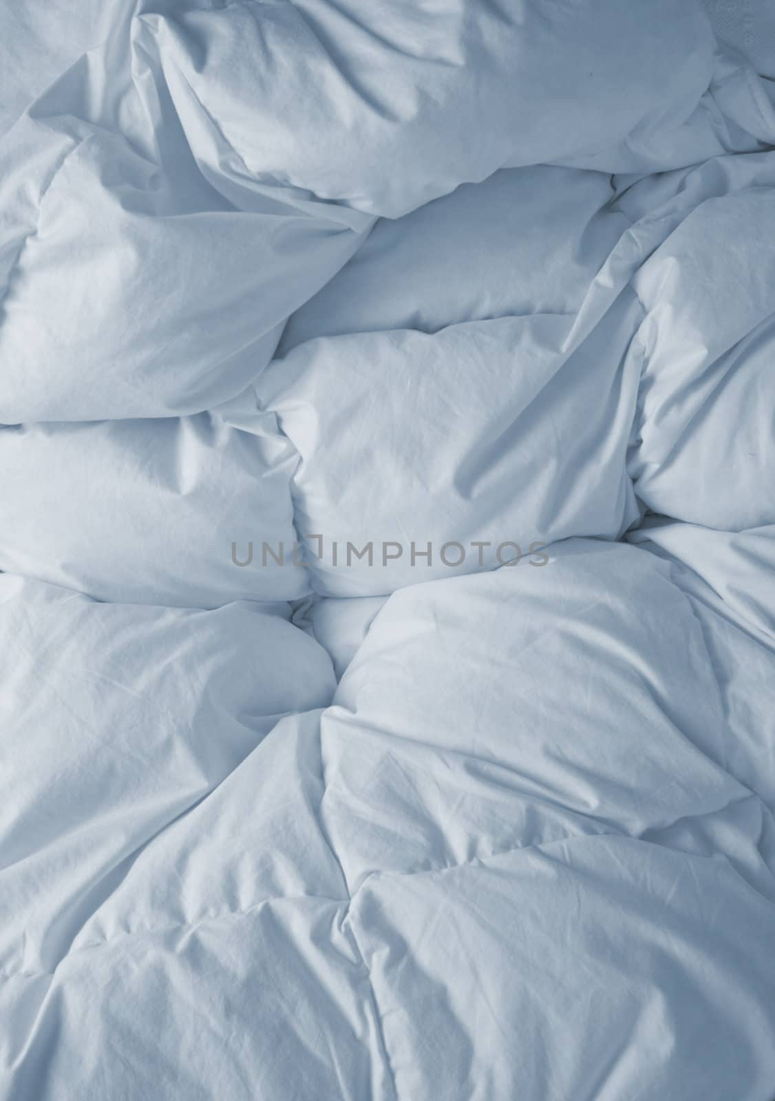 Bedclothes broken with white sheets in the morning. upright