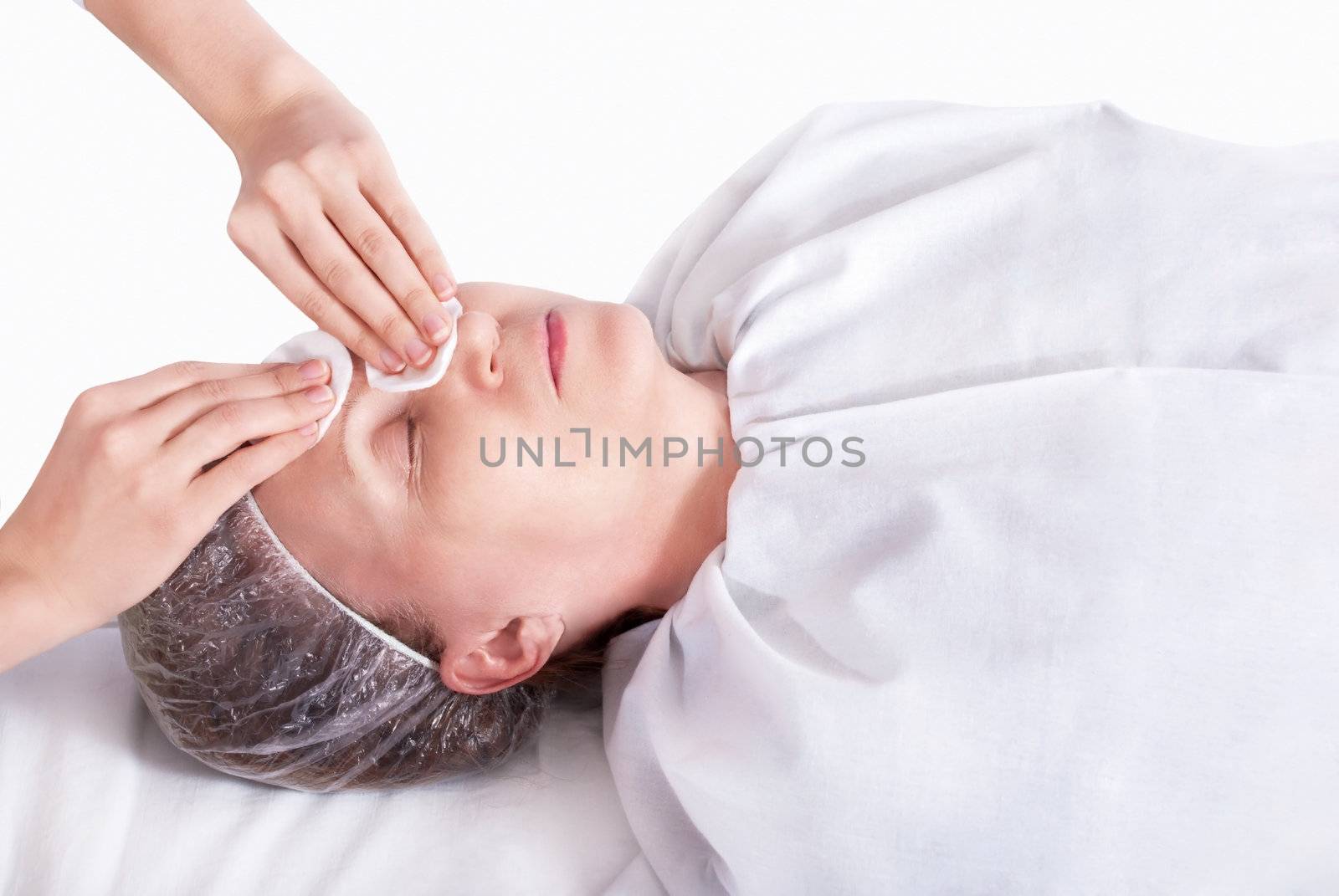 Beautiful woman in spa salon on the cleaning procedure of the face.