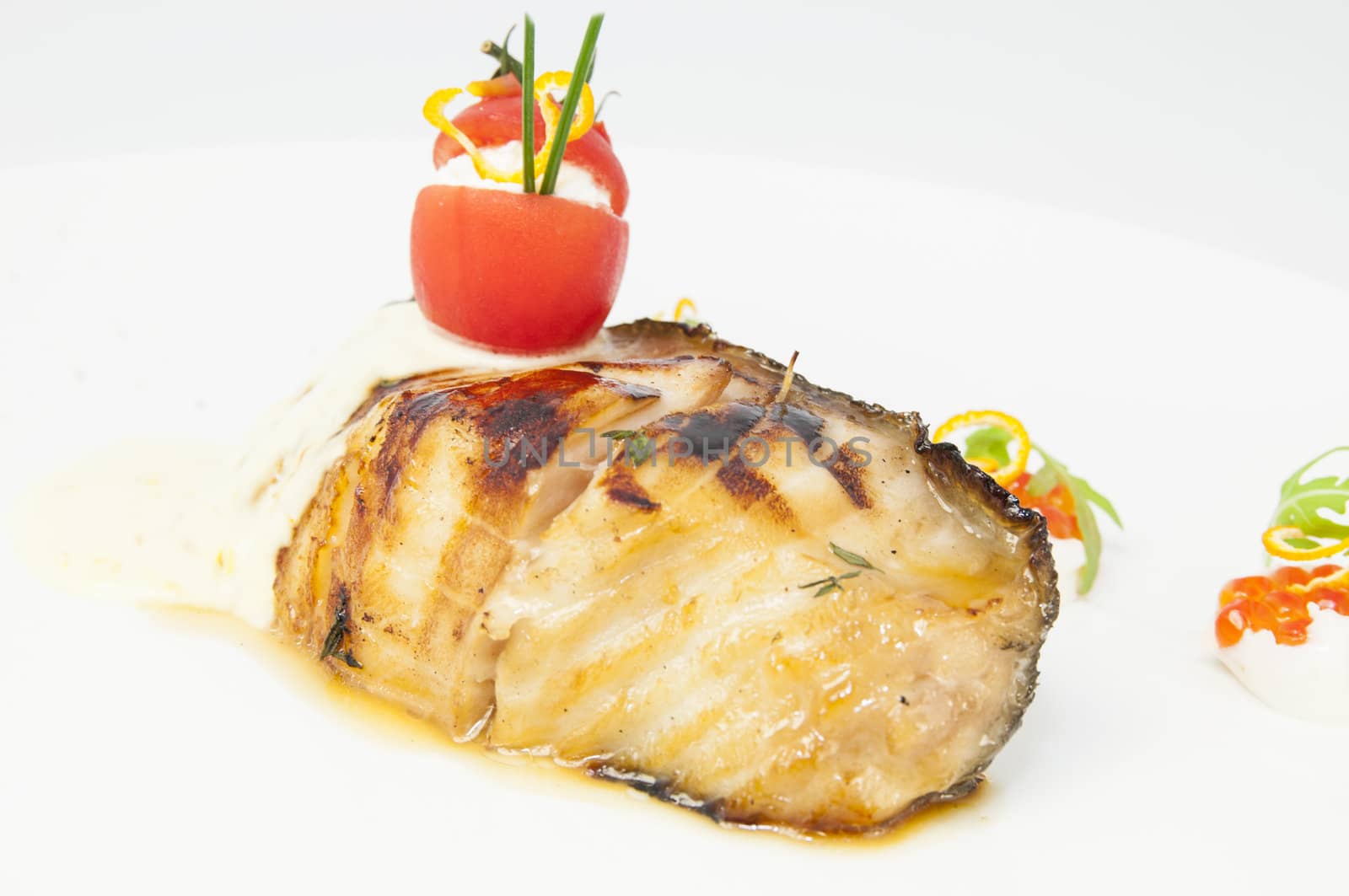 Roasted fillet of grilled fish in a white sauce
