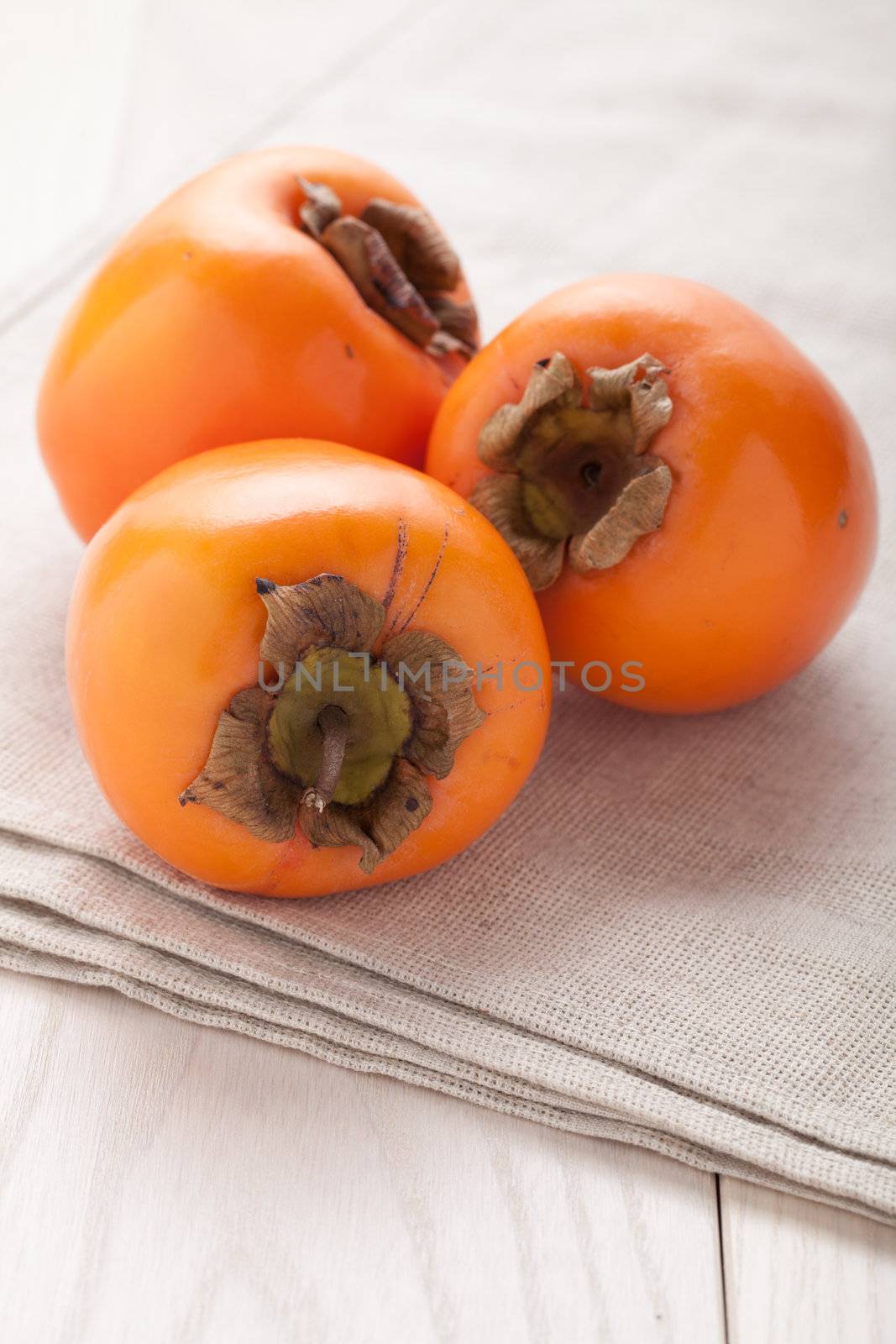 Fresh exotic tropic ripe juicy orange fruits  persimmon Diospyros served on textile towel