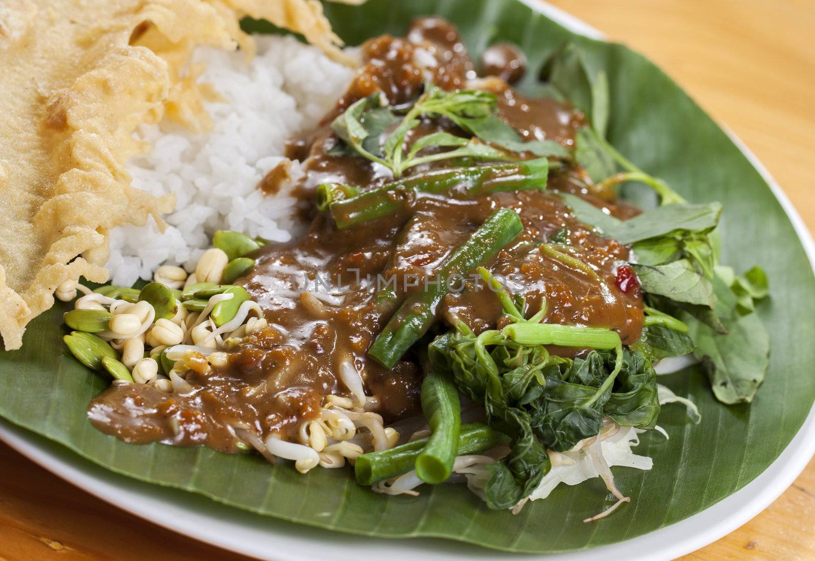 Nasi pecel is a Javanese rice dish served with mix vegetables and peanut sauce