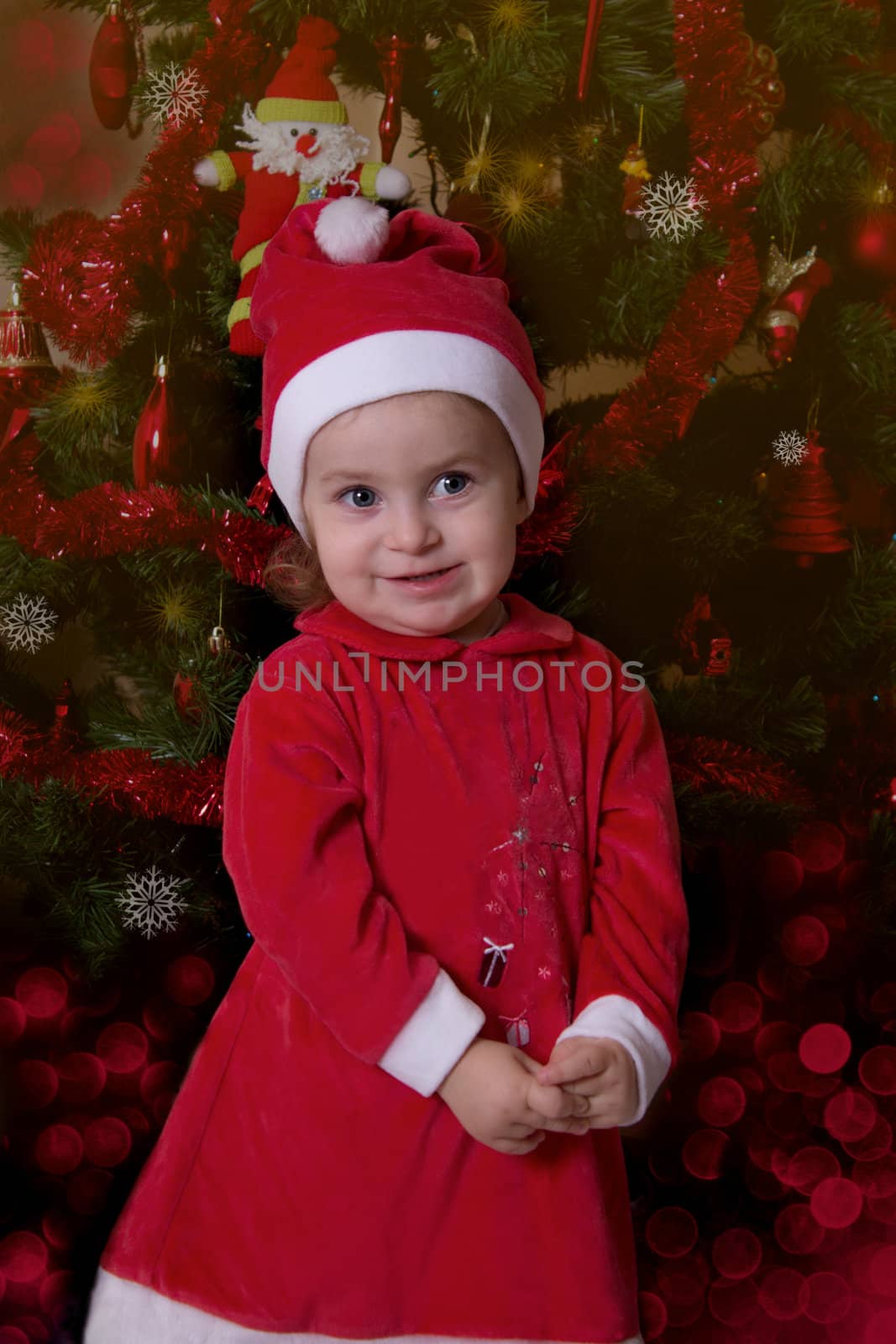 Baby girl Santa Helper under Christmas tree