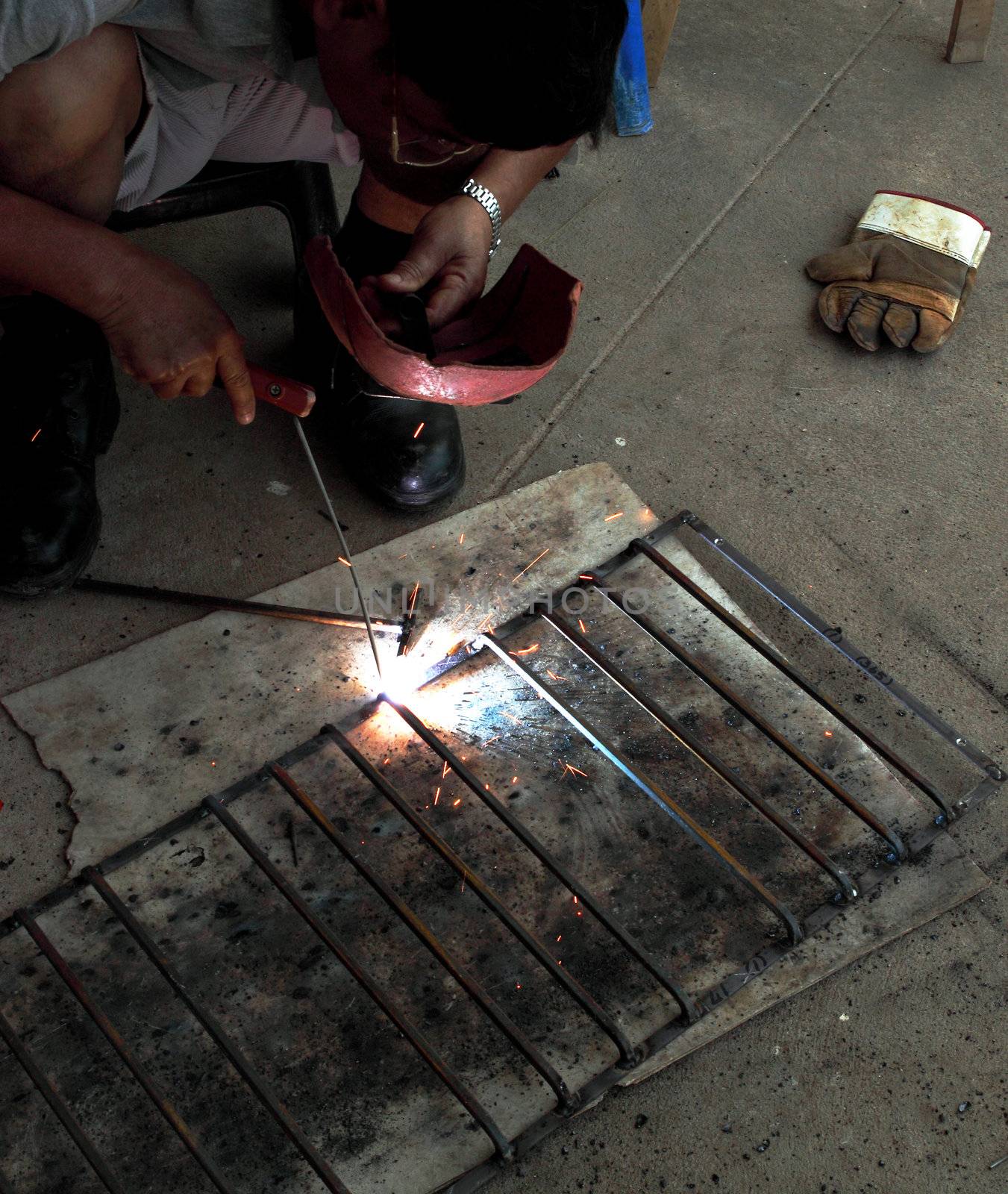 worker welding connecting square bar  without gloves