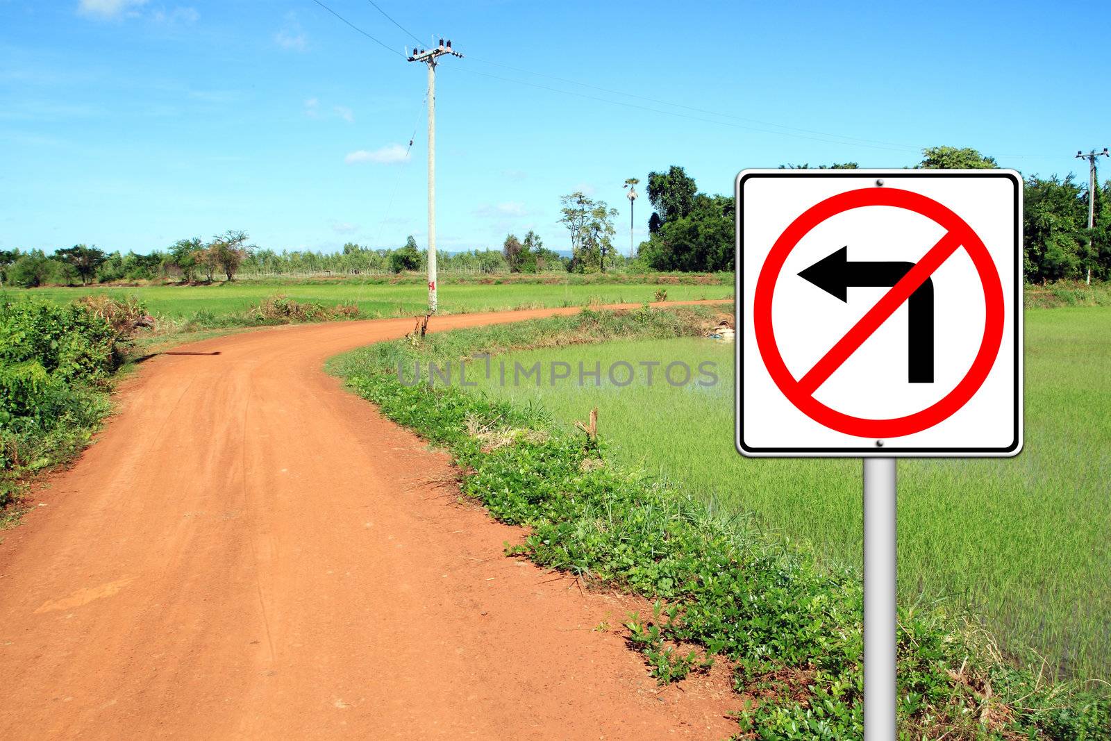 don't turn left sign with a left curved soil road