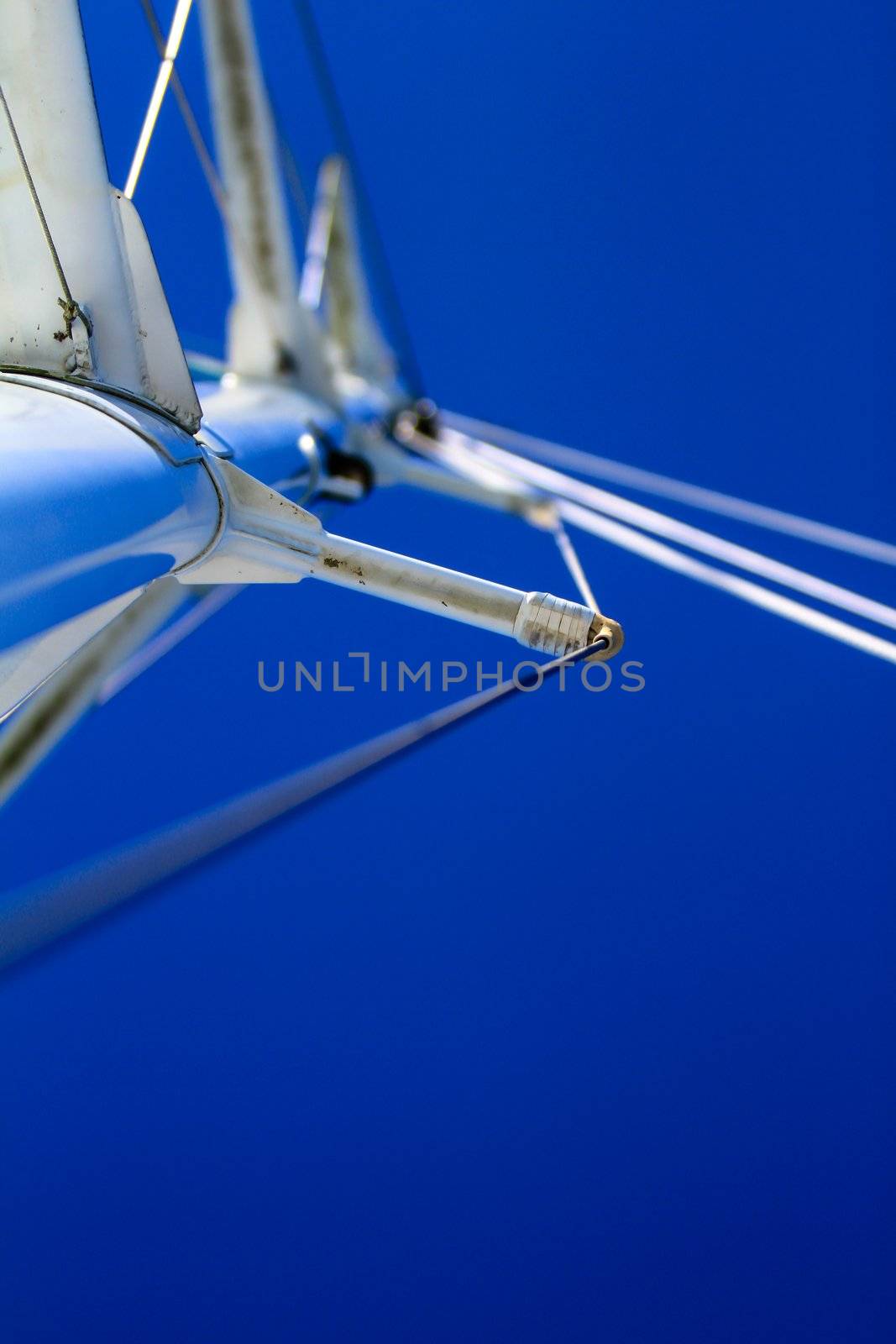 Looking at boat mast with rigging and blue sky by hangingpixels