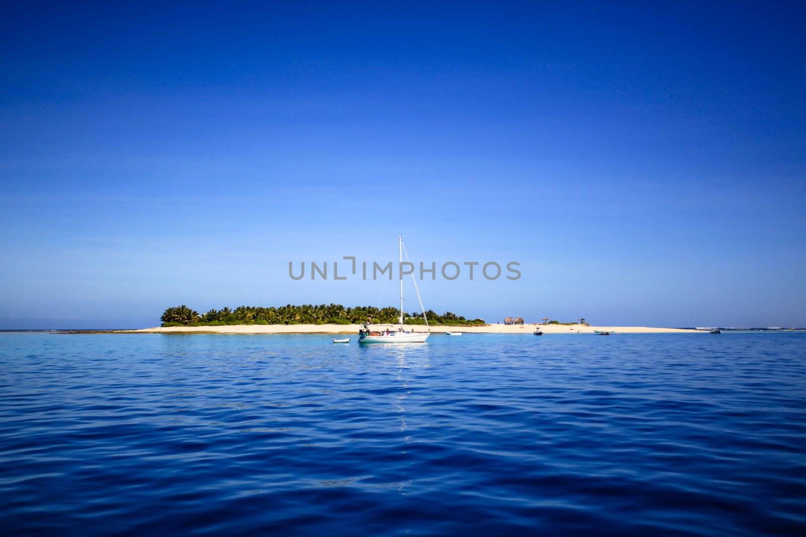 Boat and beautiful Fiji atoll island with white beach by hangingpixels