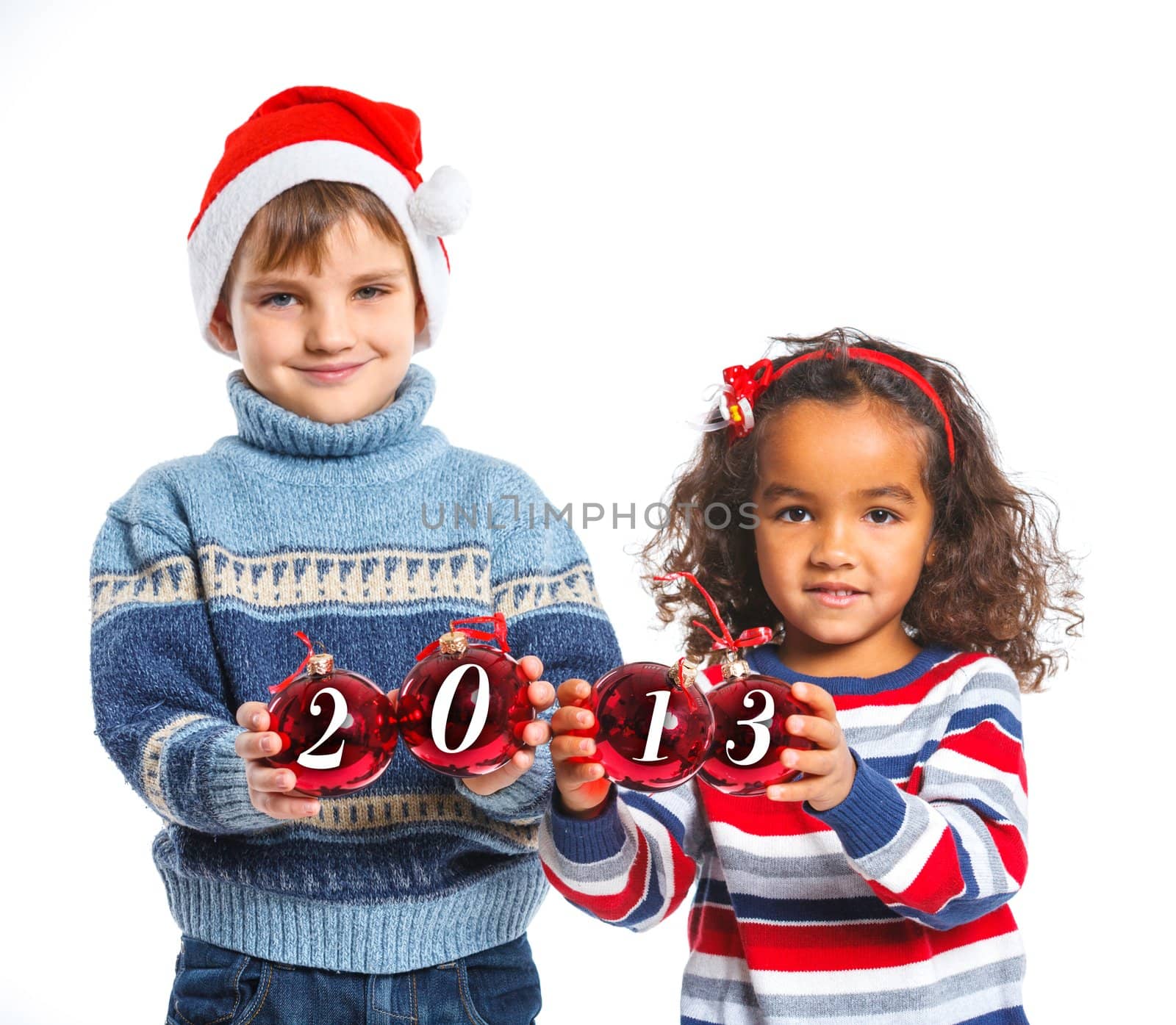 Christmas theme - Kids in Santa's hat holding a christmas ball with 2013 against a white background. Focus on the ball