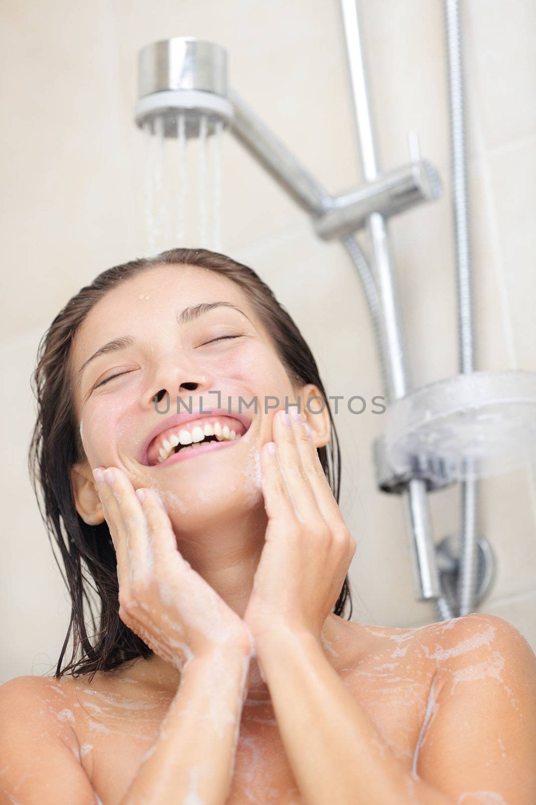 Woman washing face in shower by Ariwasabi