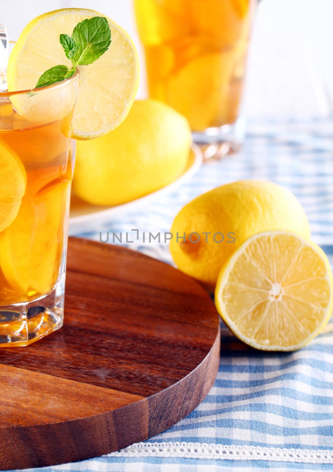 Close up of fresh and cold ice tea with sliced lemon and mint