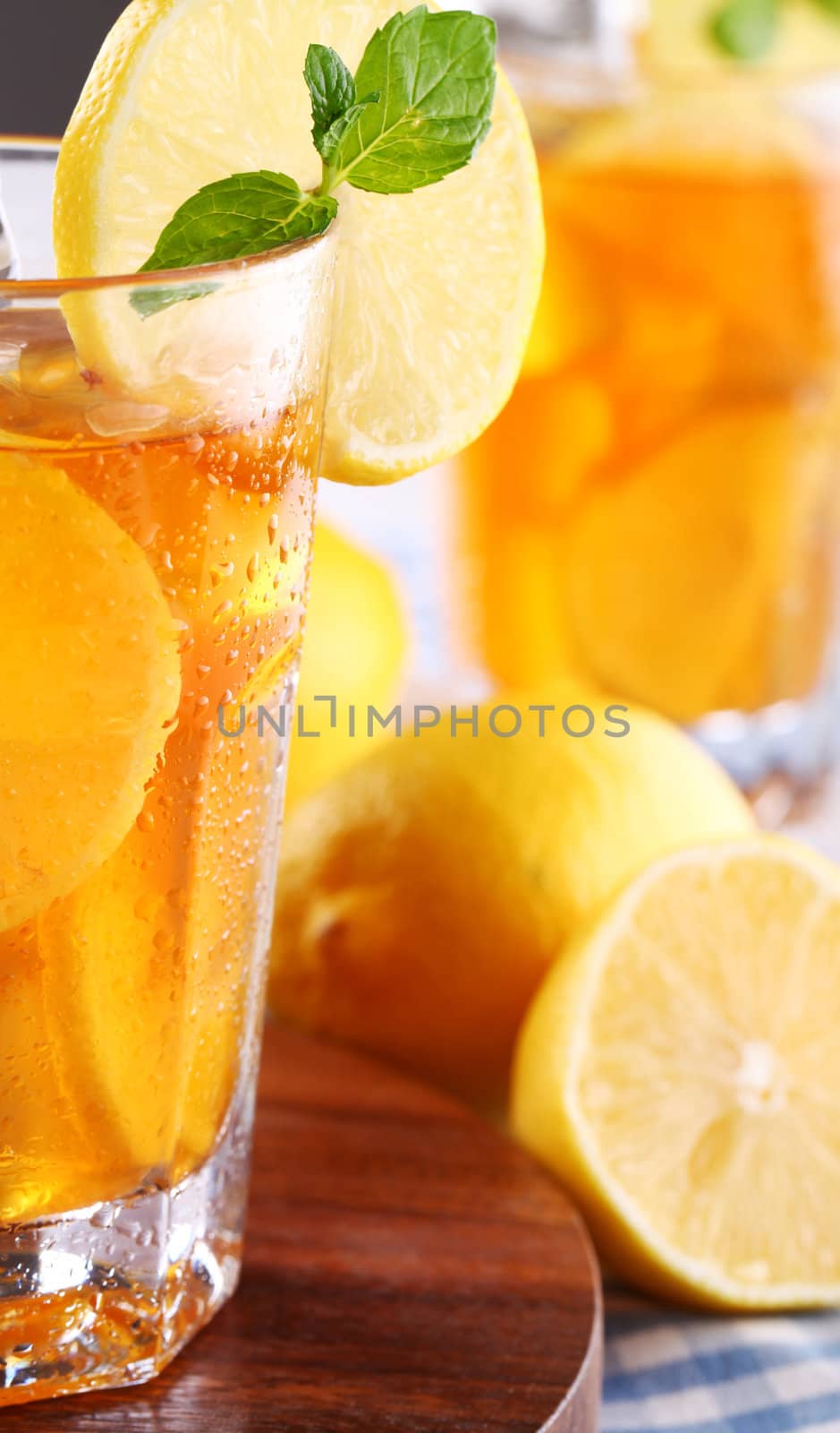 Close up of fresh and cold ice tea with sliced lemon and mint