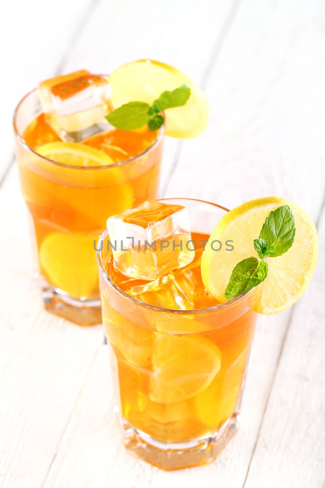 Fresh and cold ice tea with sliced lemon and mint