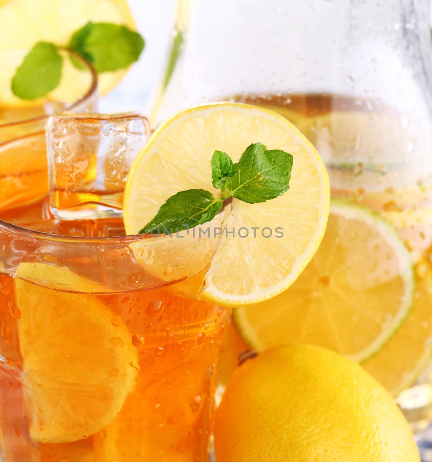 Close up of fresh and cold ice tea with sliced lemon and mint