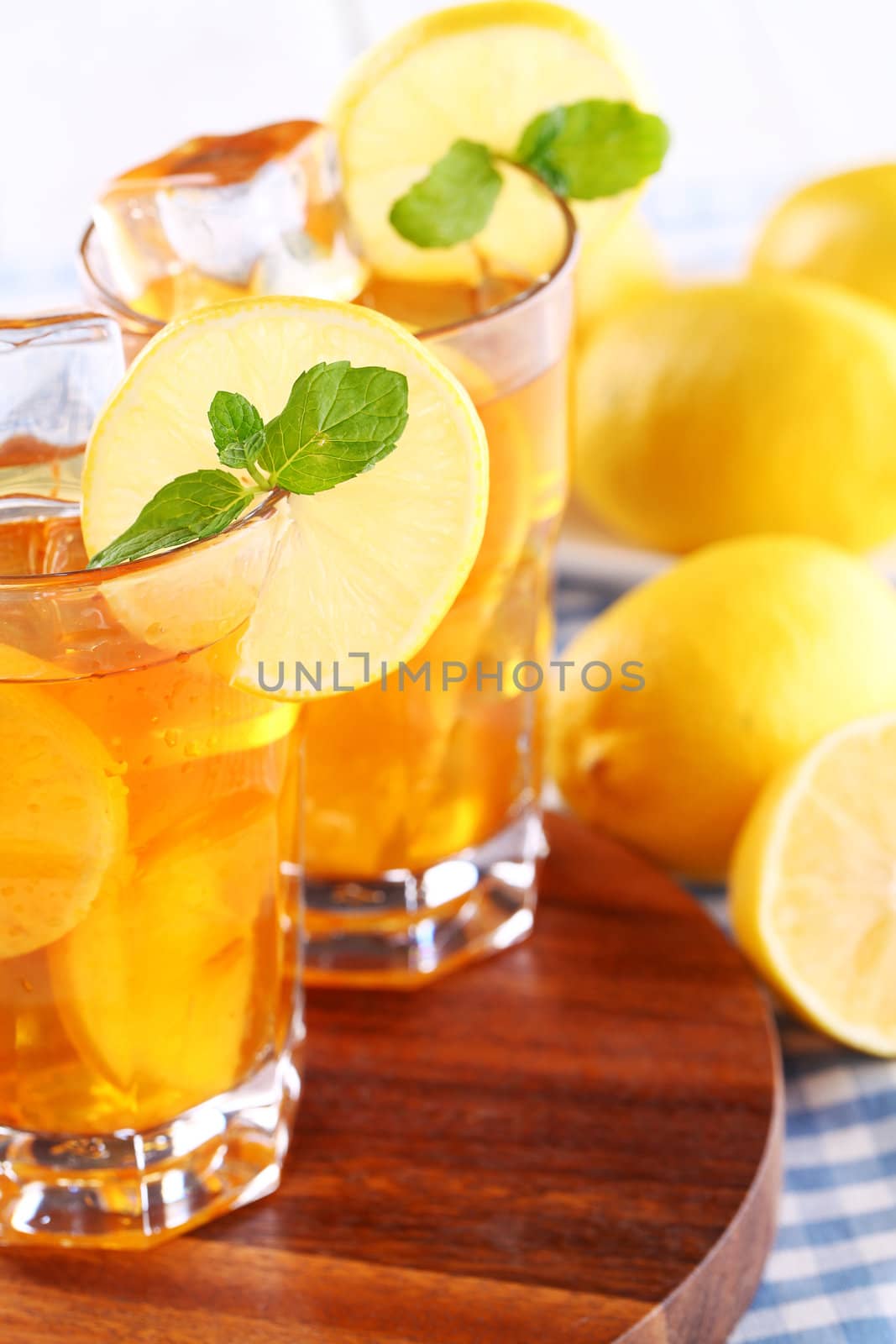 Close up of fresh and cold ice tea with sliced lemon and mint