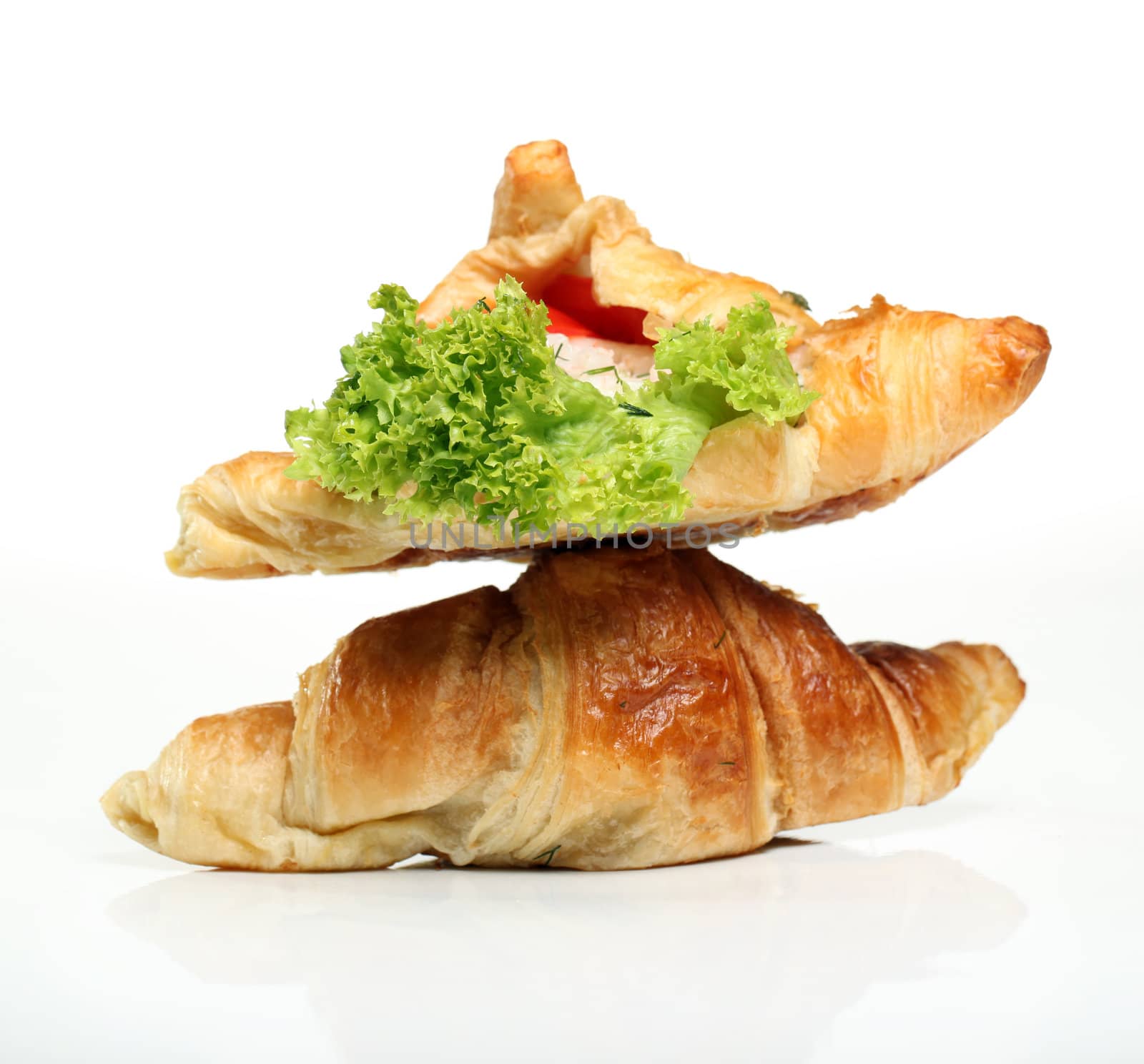 Close up of two tasty croissants with salad and tomato inside