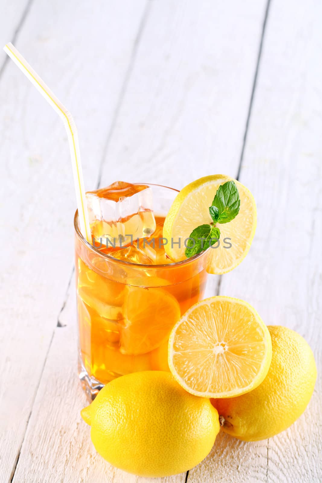 Fresh and cold ice tea with sliced lemon and mint