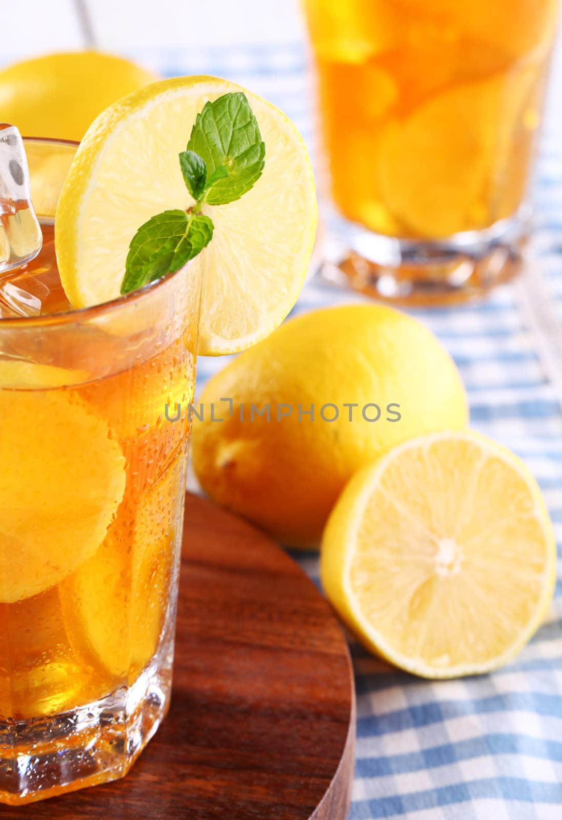 Close up of fresh and cold ice tea with sliced lemon and mint