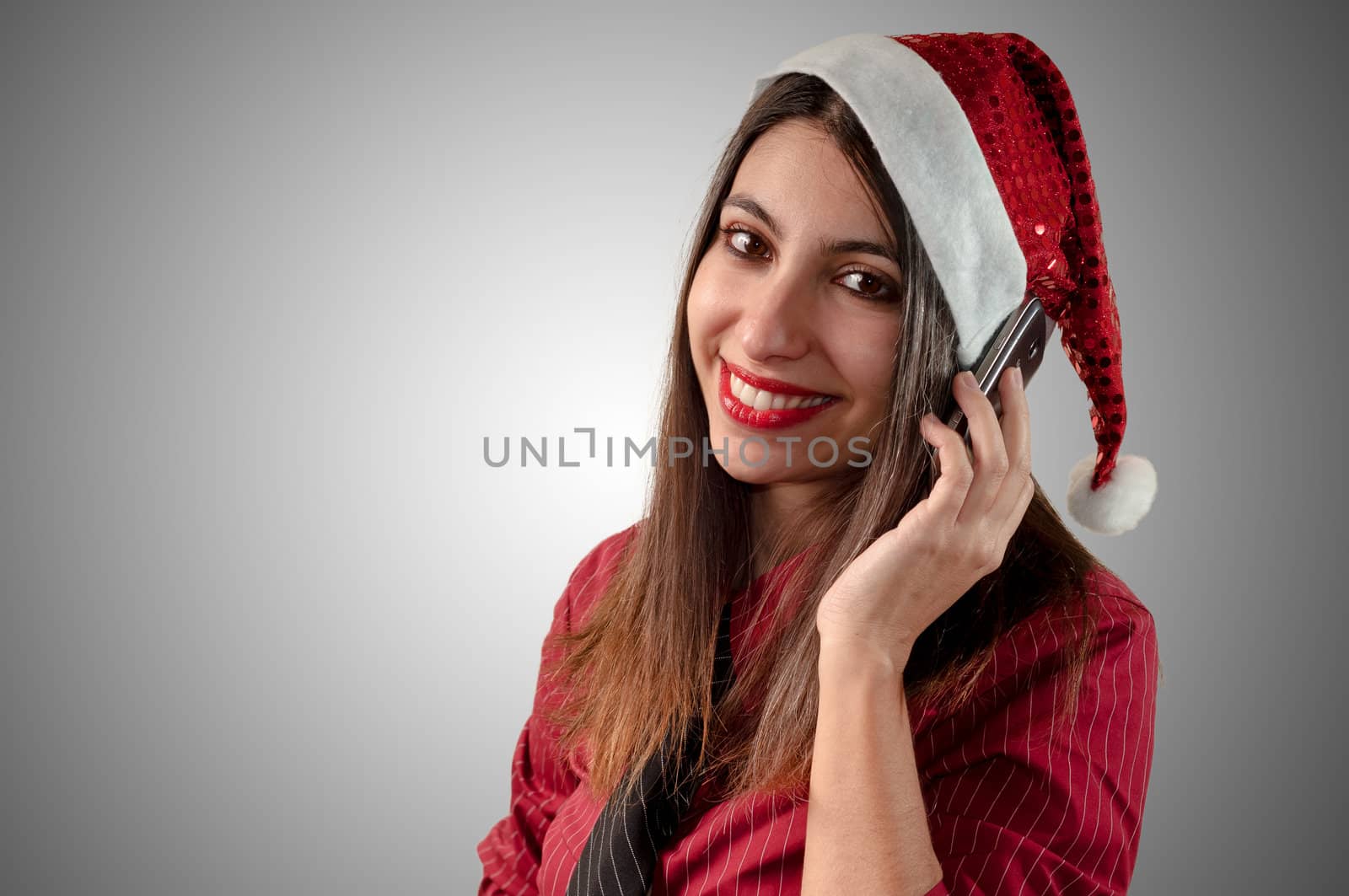 smiling business christmas girl at the phone on grey background
