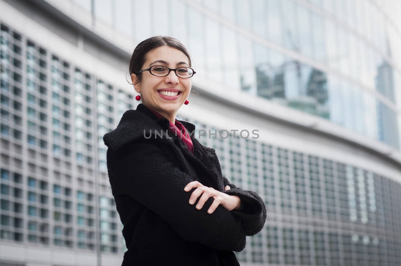 smiling business girl in front of a modern building