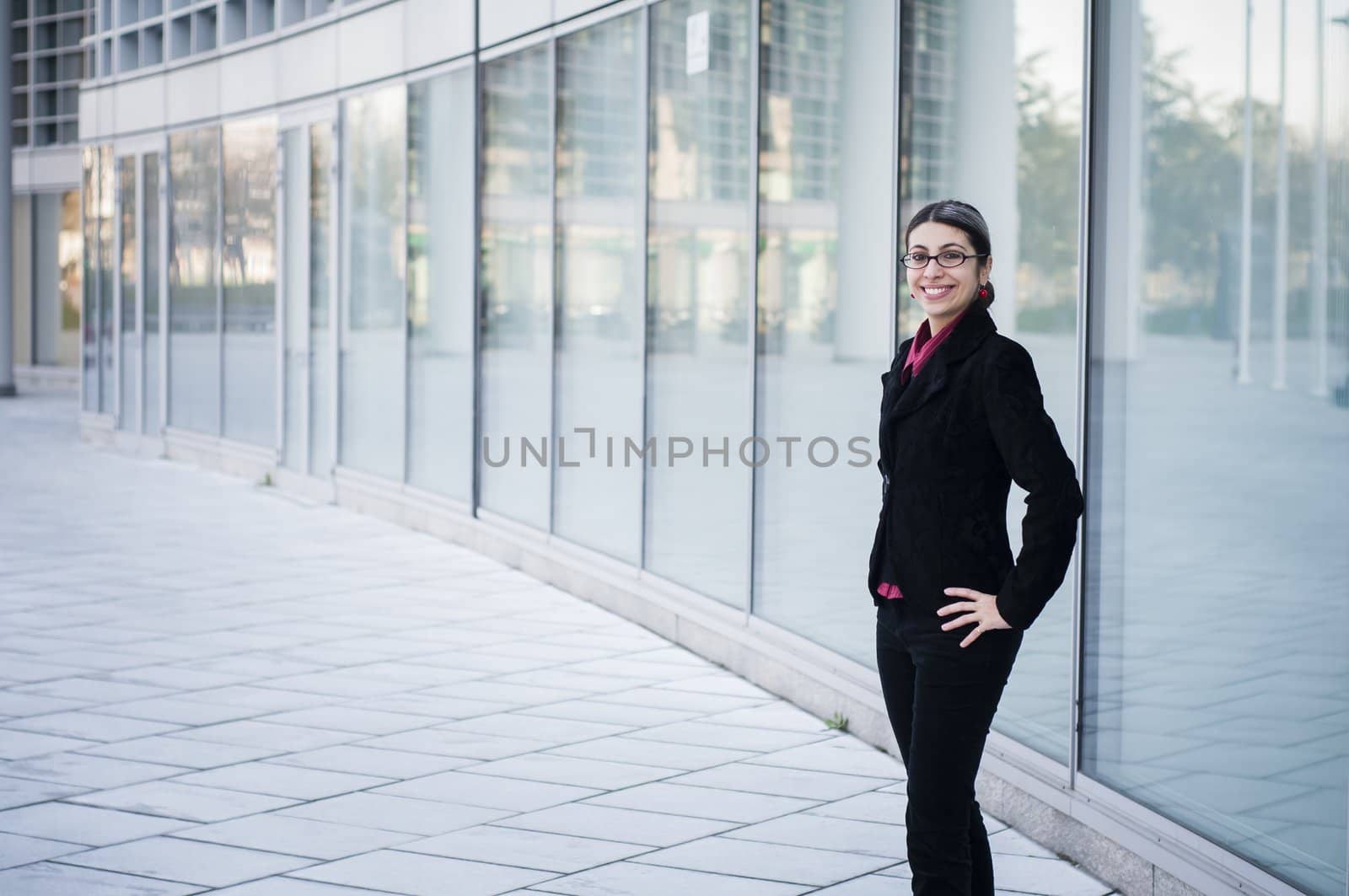 smiling business girl in front of modern building