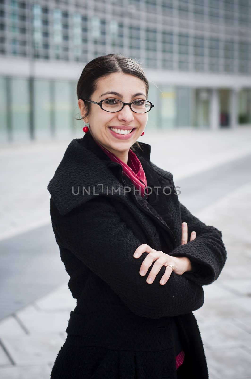 smiling business girl in front of a modern building