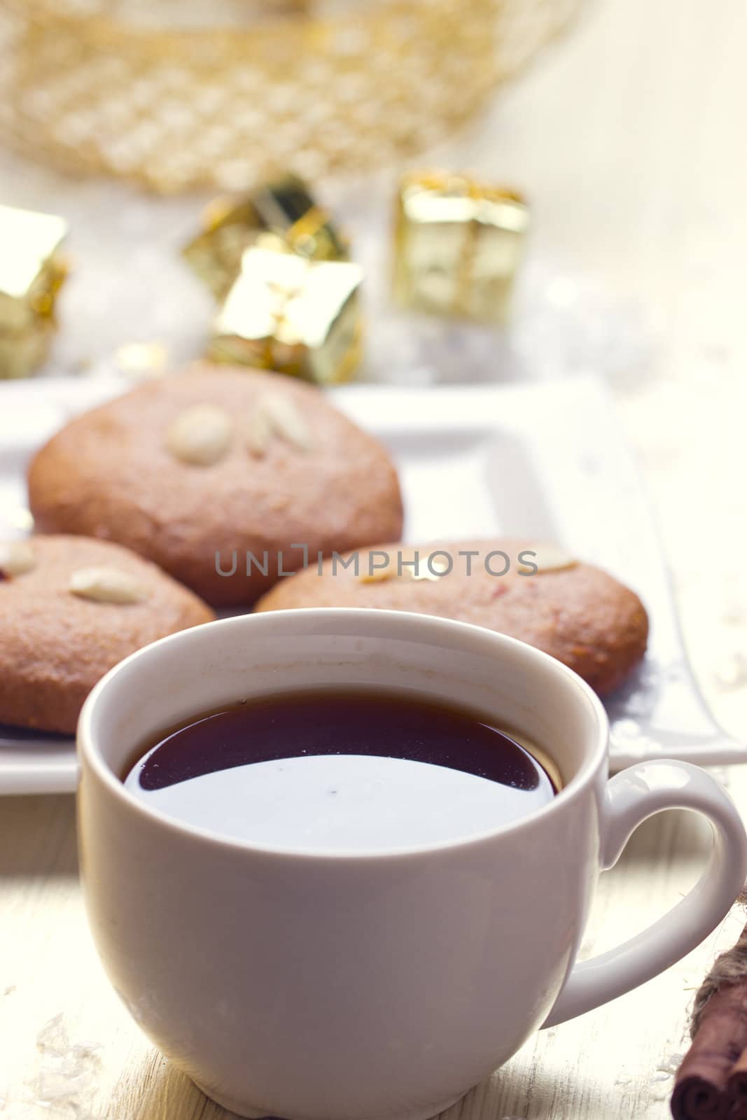 Cookies with nuts and a cup of tea on a background of Christmas gifts