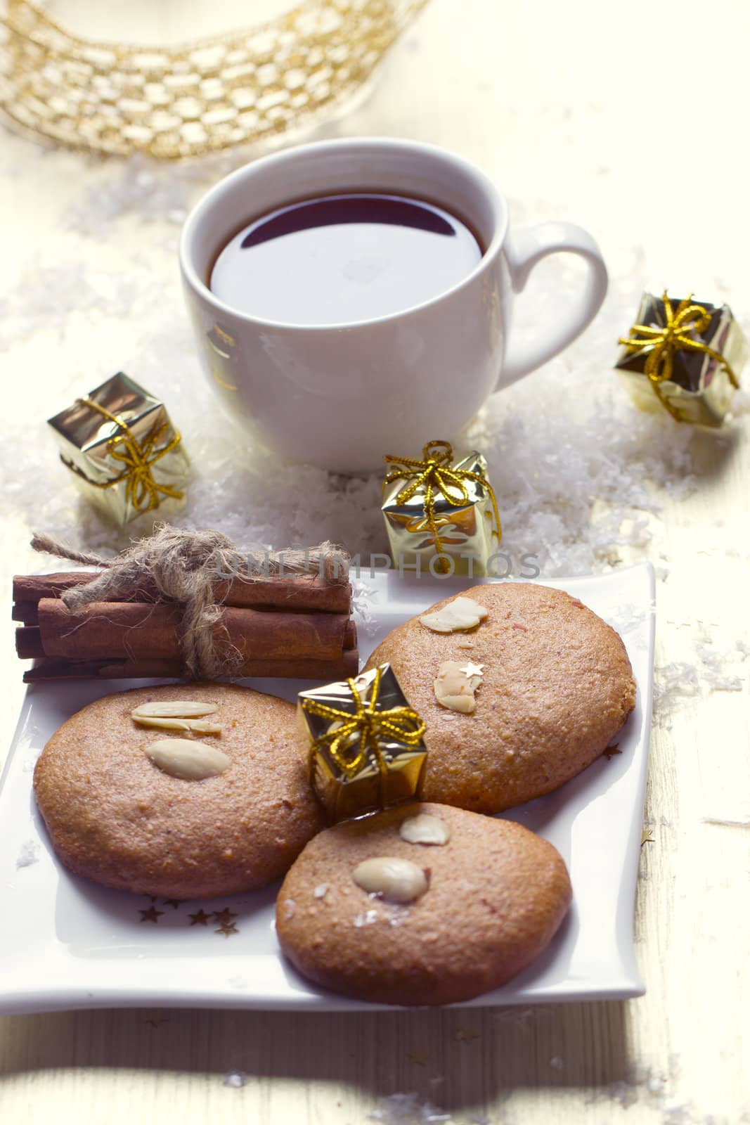 Cookies with nuts and a cup of tea on a background of Christmas gifts