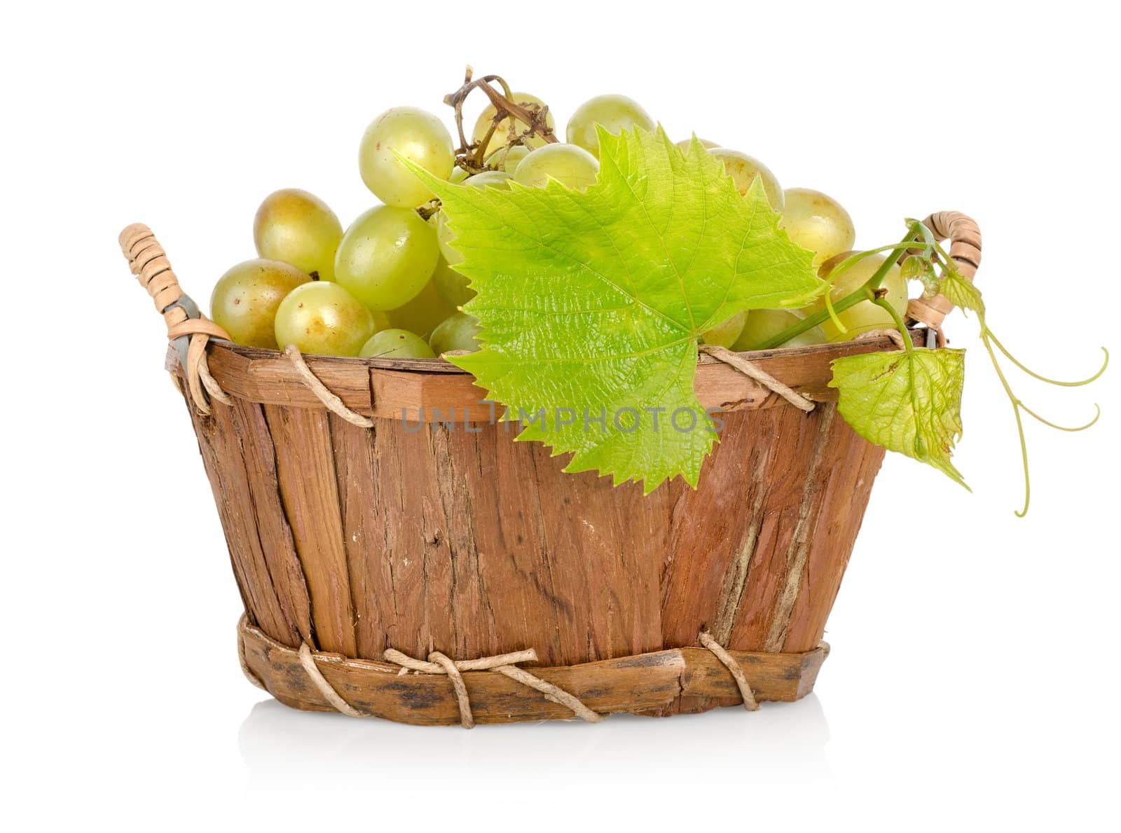 Grapes in a wooden basket isolated on white background