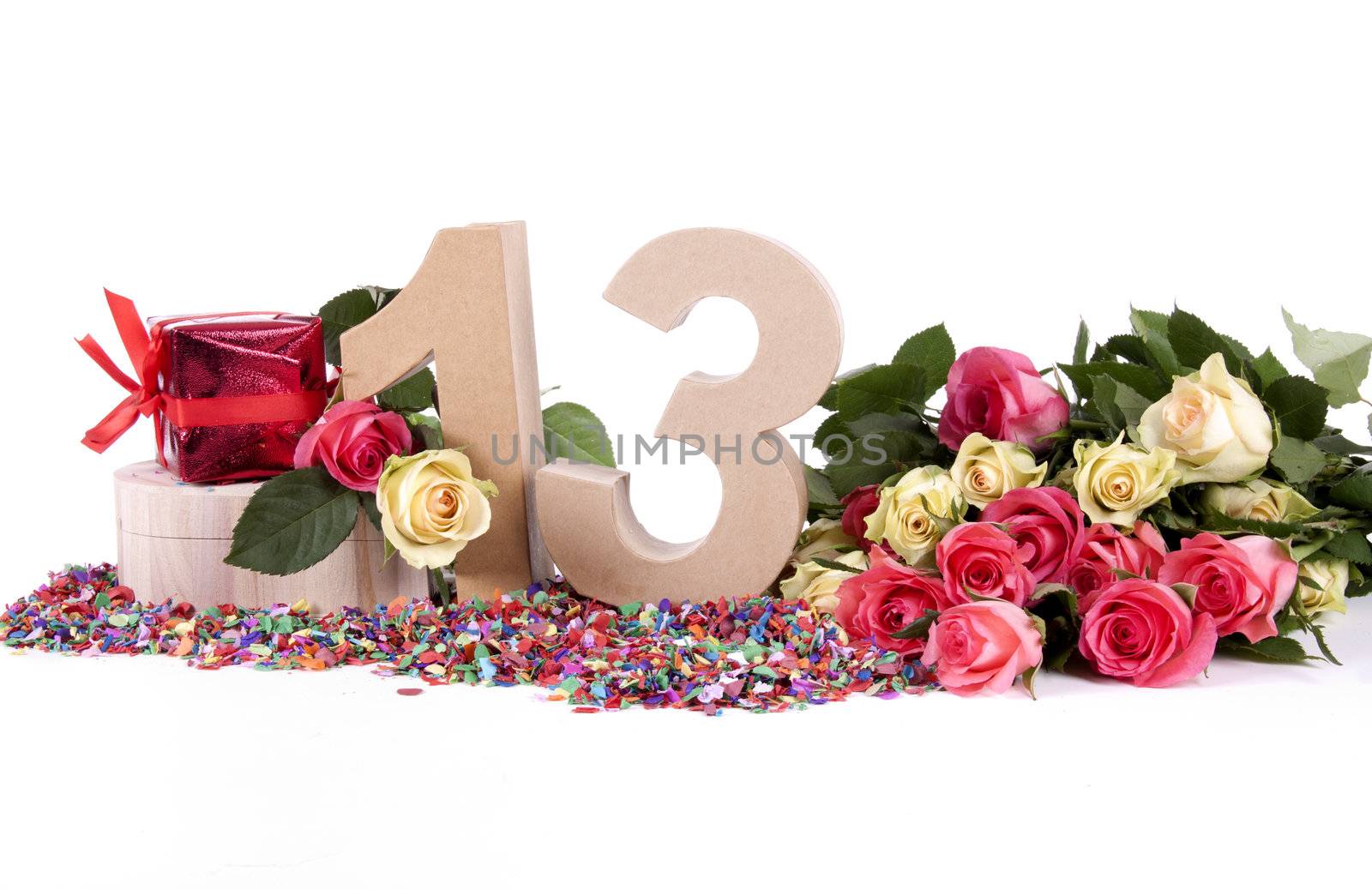 Number of age in a colorful studio setting with fresh roses on a bottom of confetti