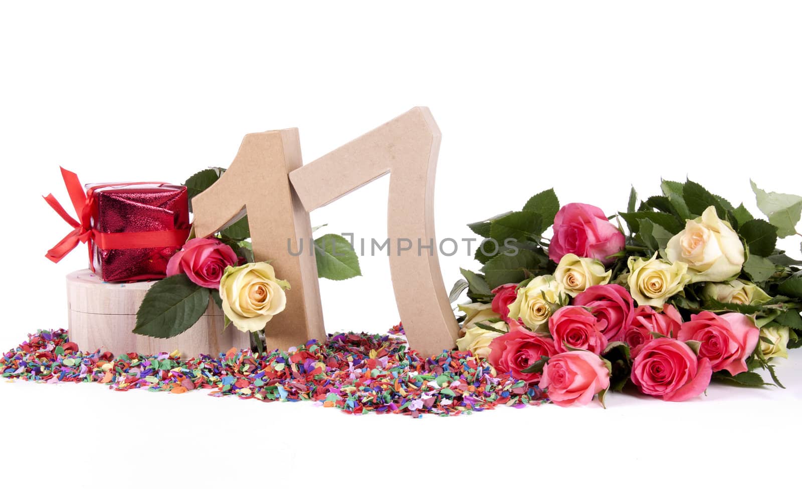 Number of age in a colorful studio setting with fresh roses on a bottom of confetti