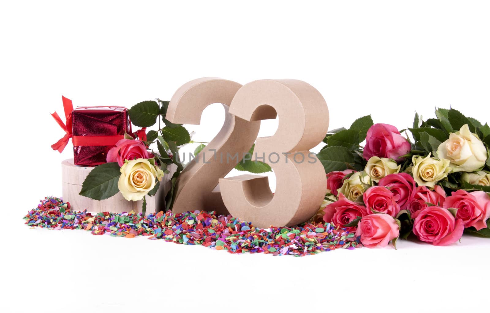 Number of age in a colorful studio setting with fresh roses on a bottom of confetti