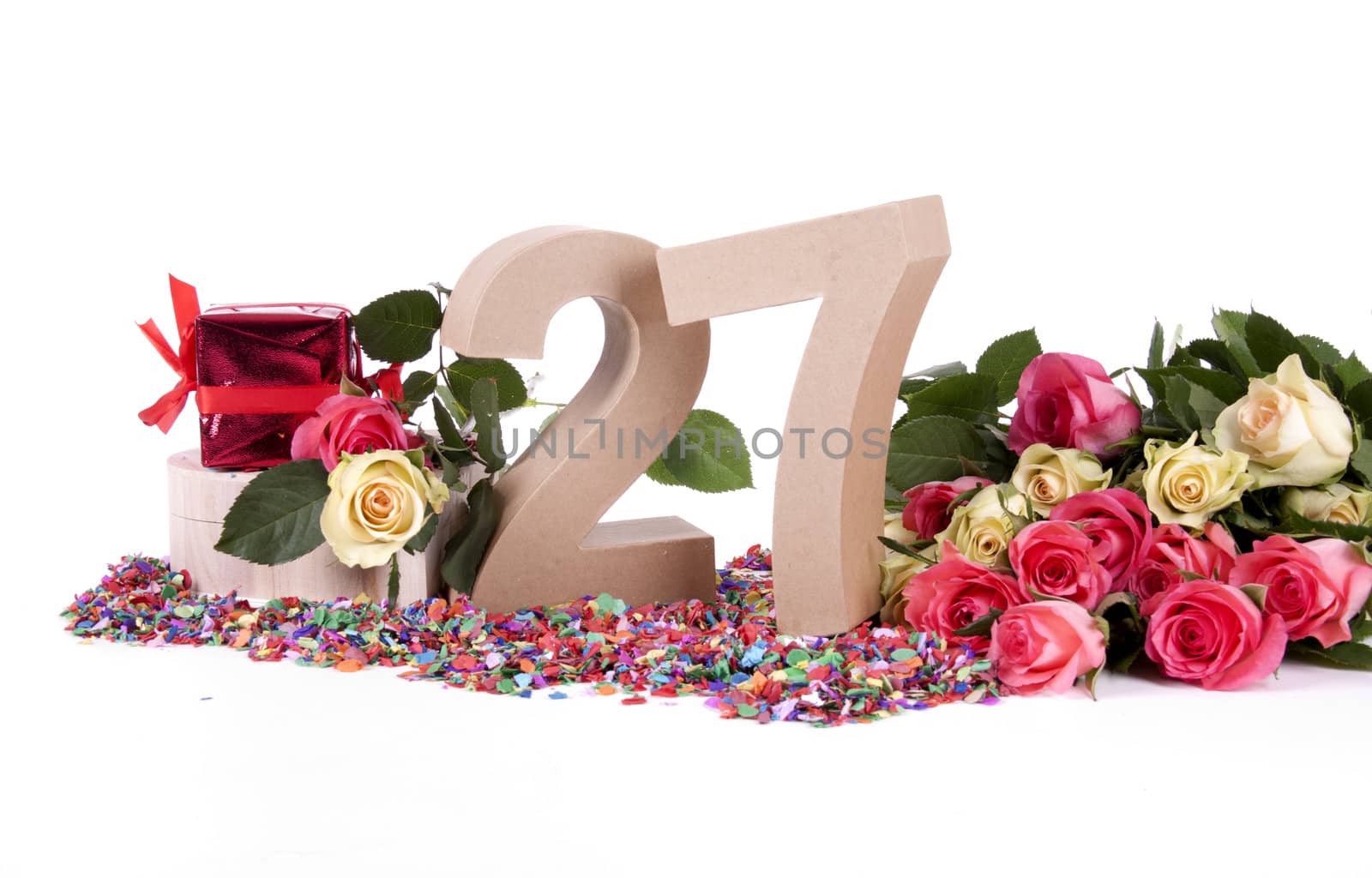 Number of age in a colorful studio setting with fresh roses on a bottom of confetti