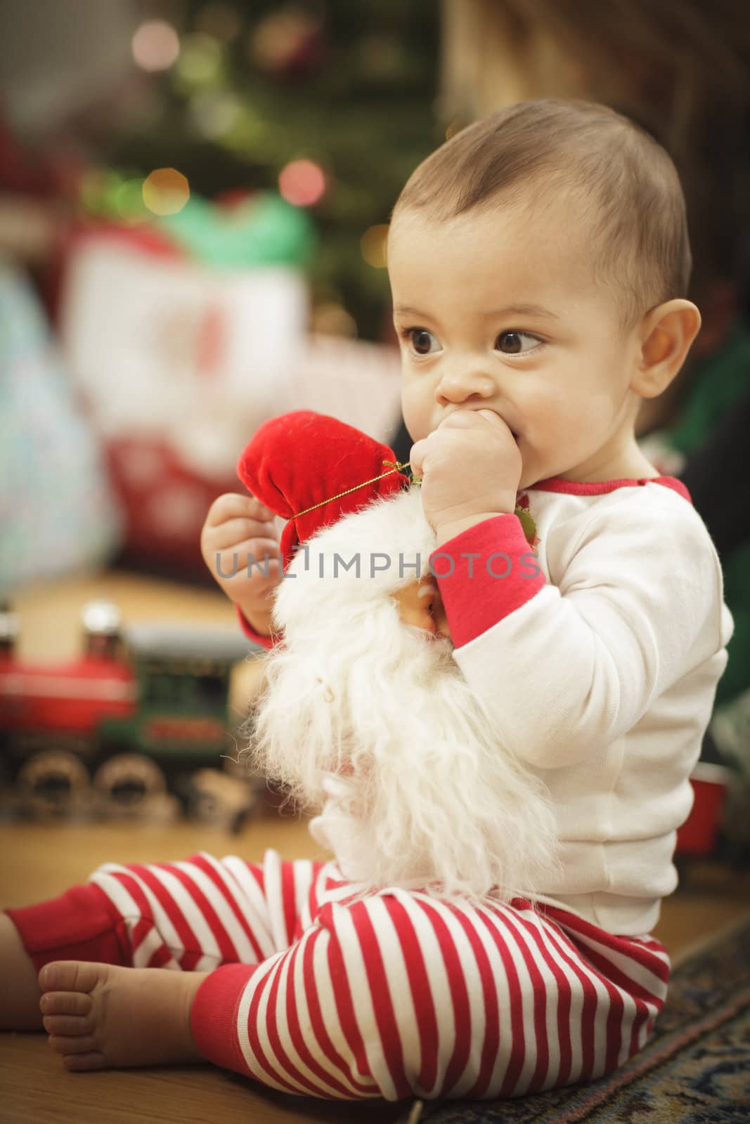 Cute Infant Baby Enjoying Christmas Morning Near The Tree.