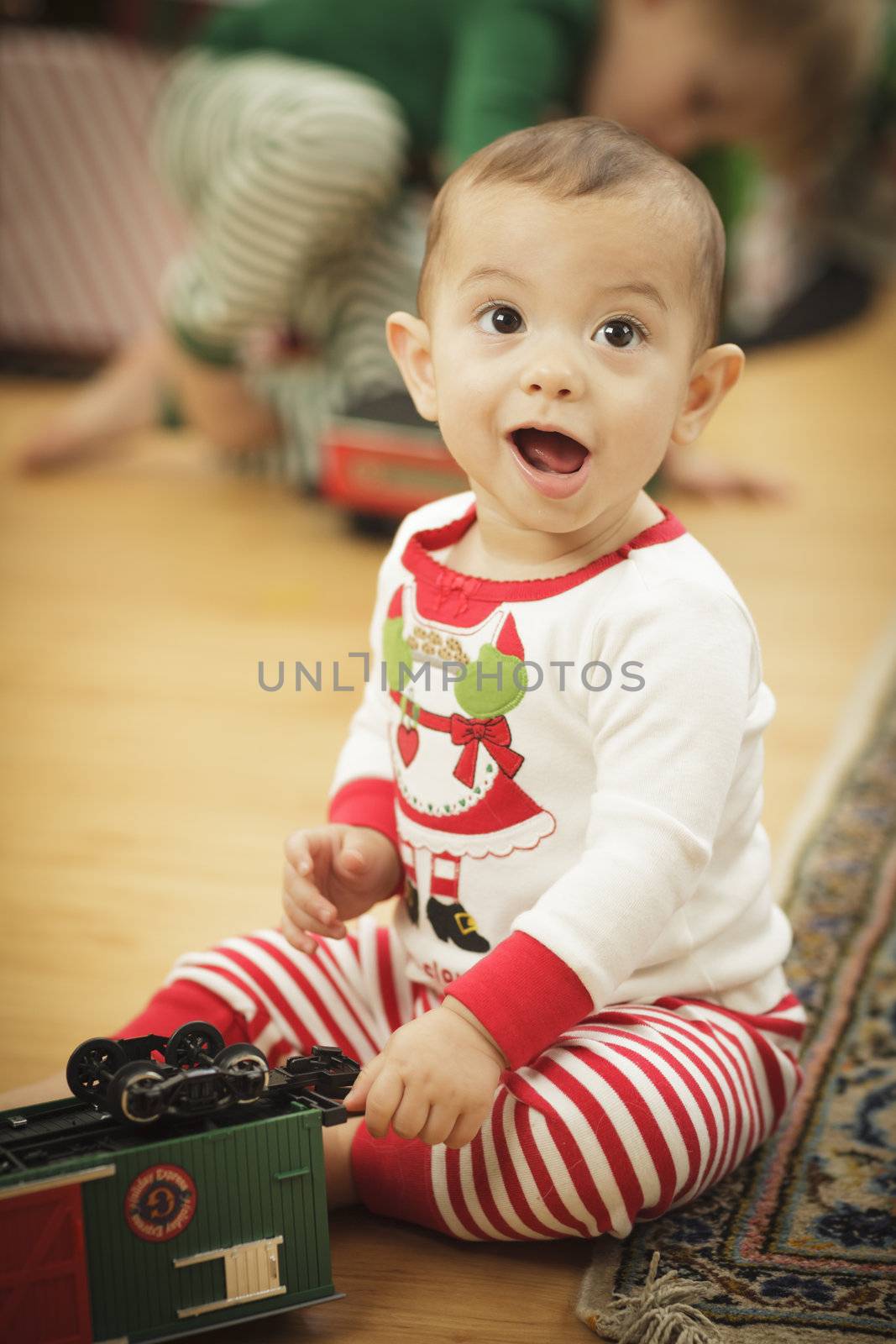 Cute Infant Baby Enjoying Christmas Morning Near The Tree.