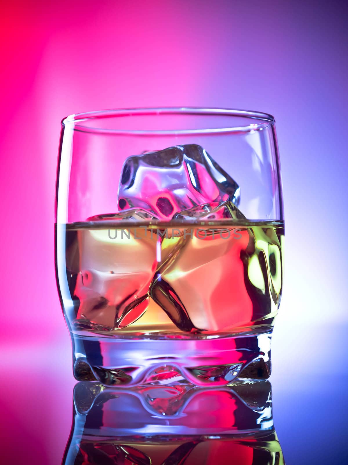 Whiskey on the rocks over vibrant red and blue background