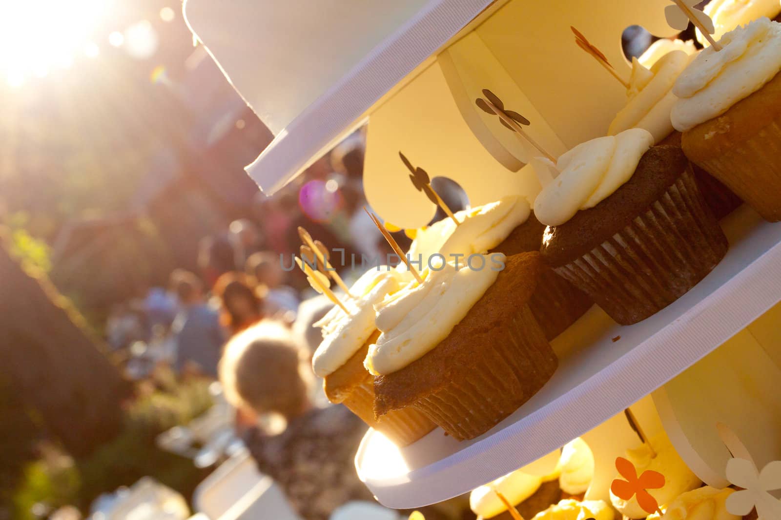 Three types of wedding cupcakes at a dessert recepition outdoors.