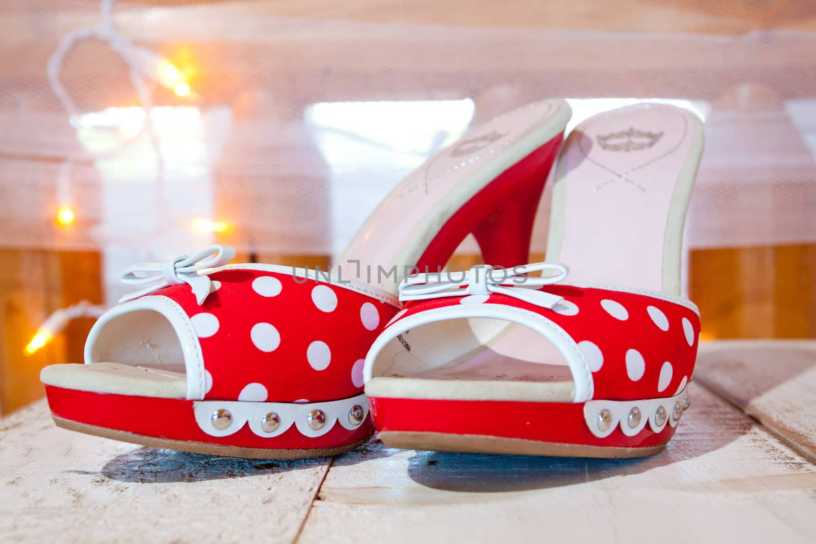 A bride's wedding shoes in red and white with polkadots and heels.