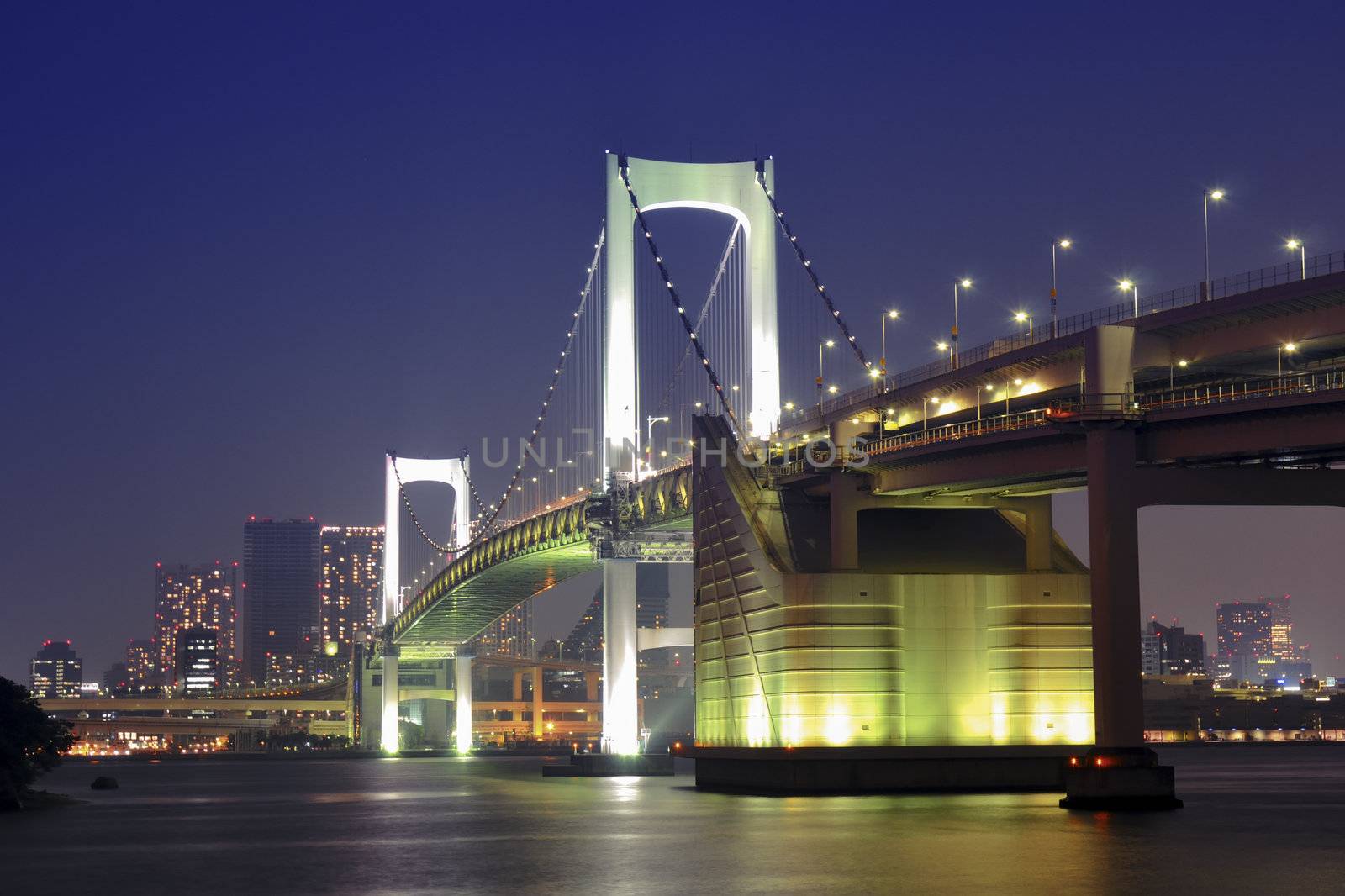 one of famous Tokyo landmarks, Tokyo Rainbow bridge over bay waters with scenic night illumination